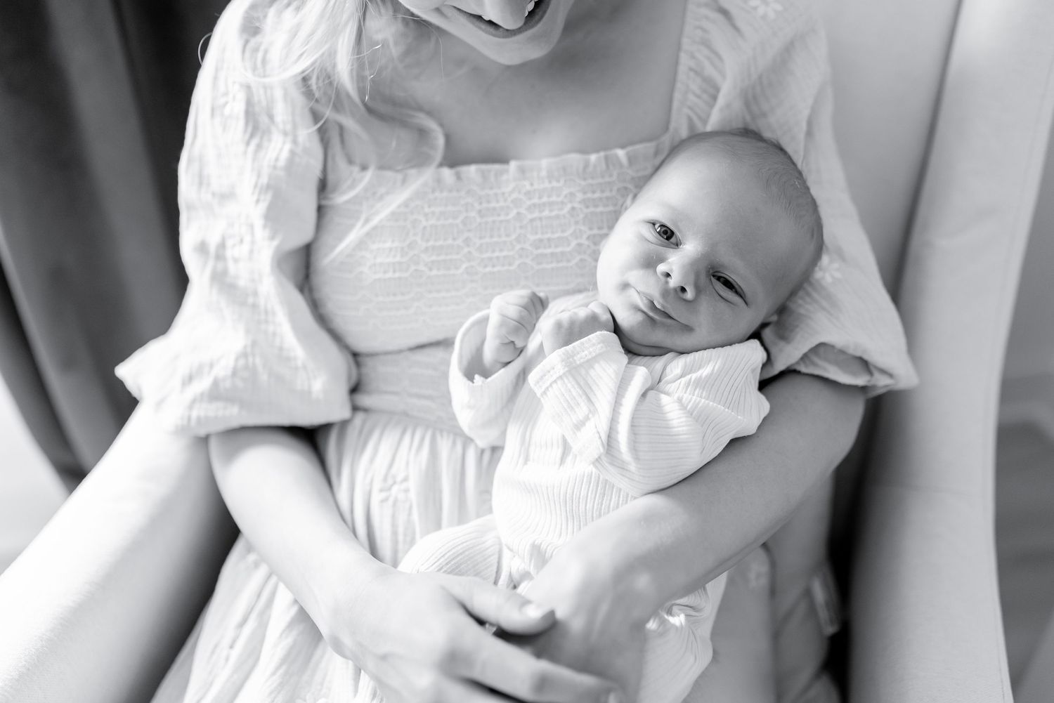 A collection of black and white photographs showing a newborn baby in various poses wearing white clothing.