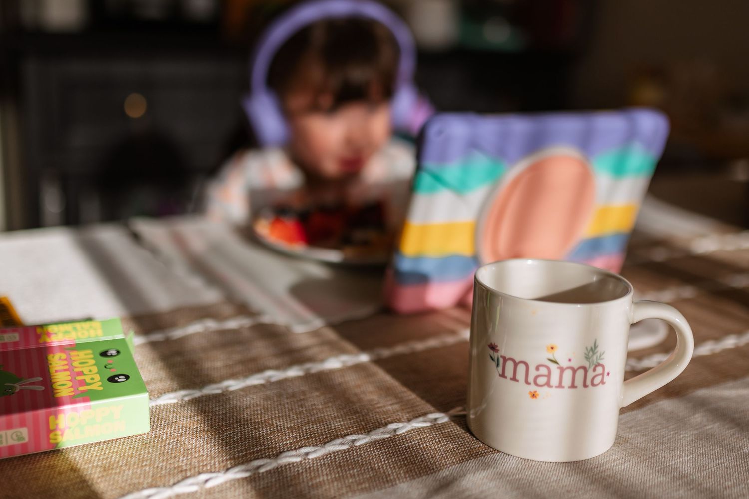 Coffee mug sits on wooden table next to colorful sticky notes in soft lighting.