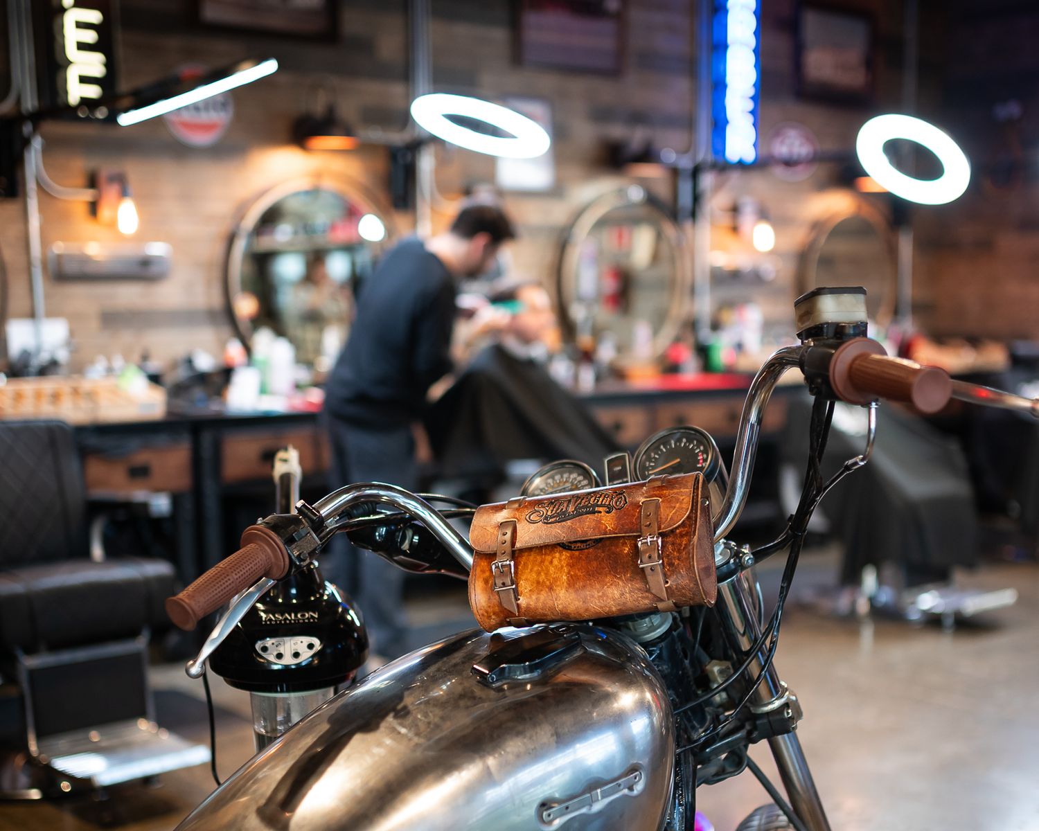 A row of vintage motorcycles parked in a dimly lit indoor space with exposed brick walls and ambient lighting.