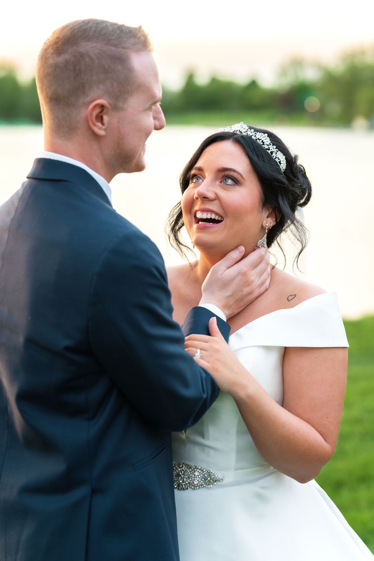 A happy bride and groom share an intimate moment outdoors during their sunset wedding photoshoot.