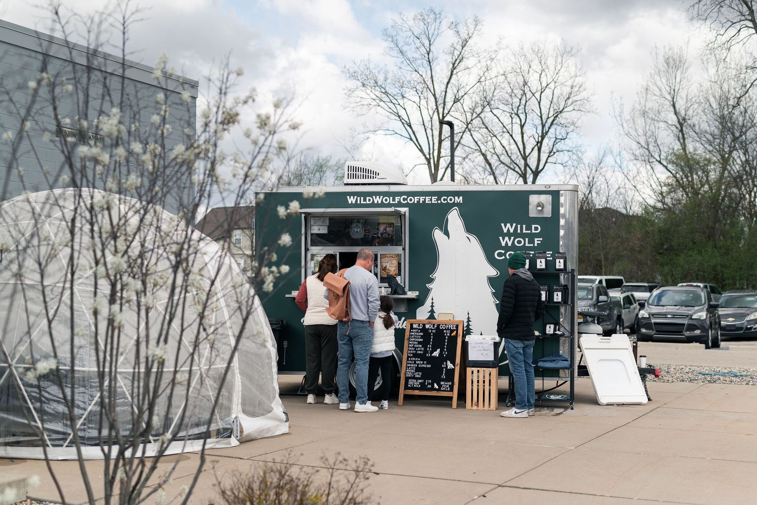 Wild Wolf Coffee food truck with customers ordering outdoors on a cloudy day.