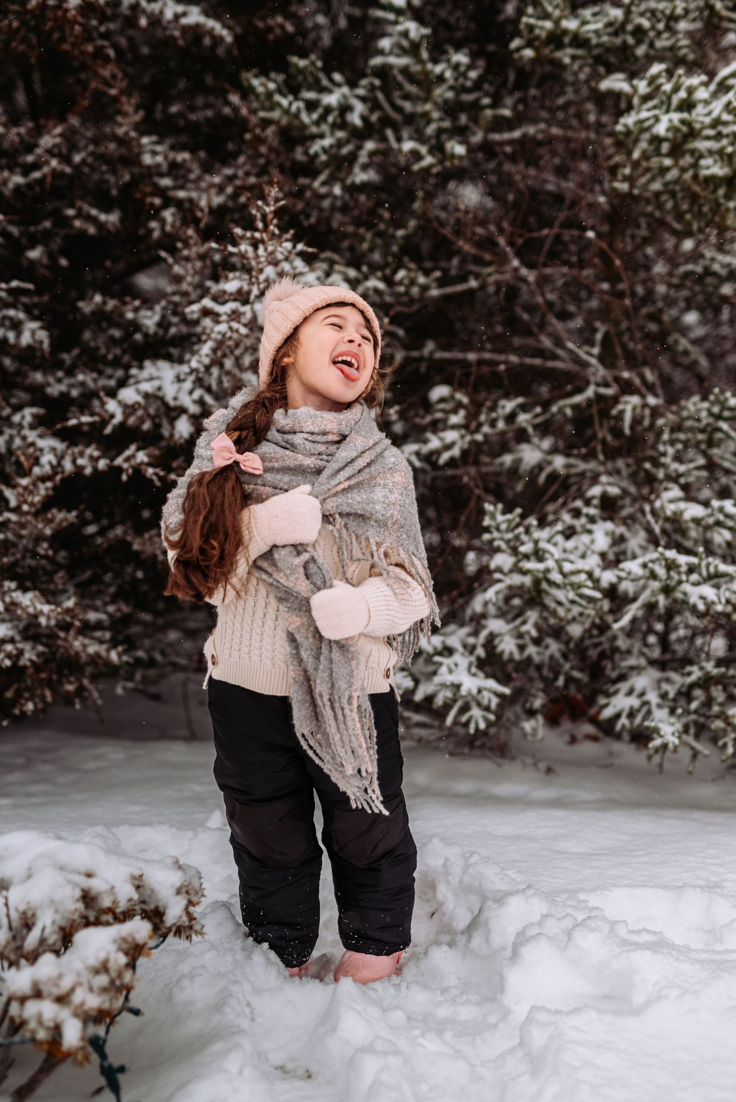 A series of winter photos showing someone playing and enjoying the fresh snow in a snowy forest setting.