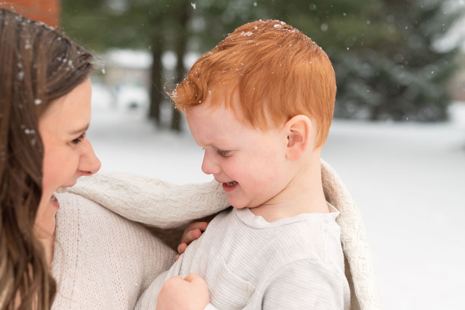 Intimate winter portrait capturing a tender moment between parent and child in the snow.