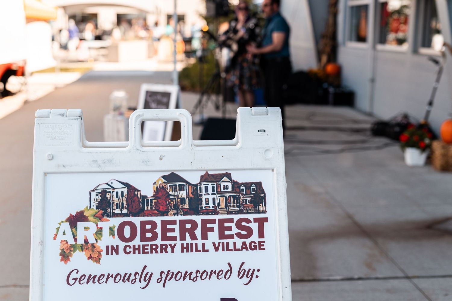 Artoberfest in Cherry Hill Village sandwich board sign generously sponsored at outdoor festival.