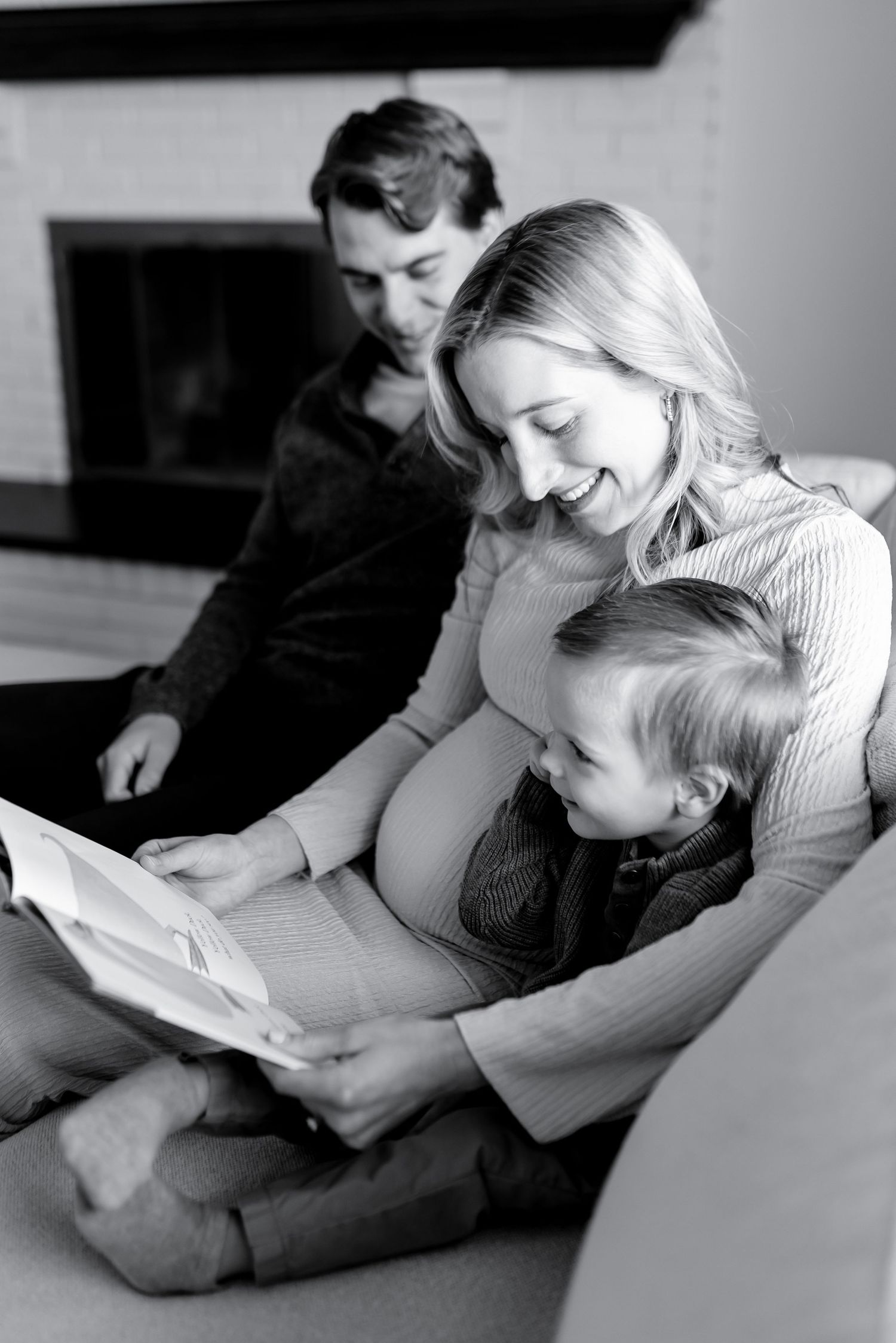 Black and white photo of a cozy family reading time on the sofa.