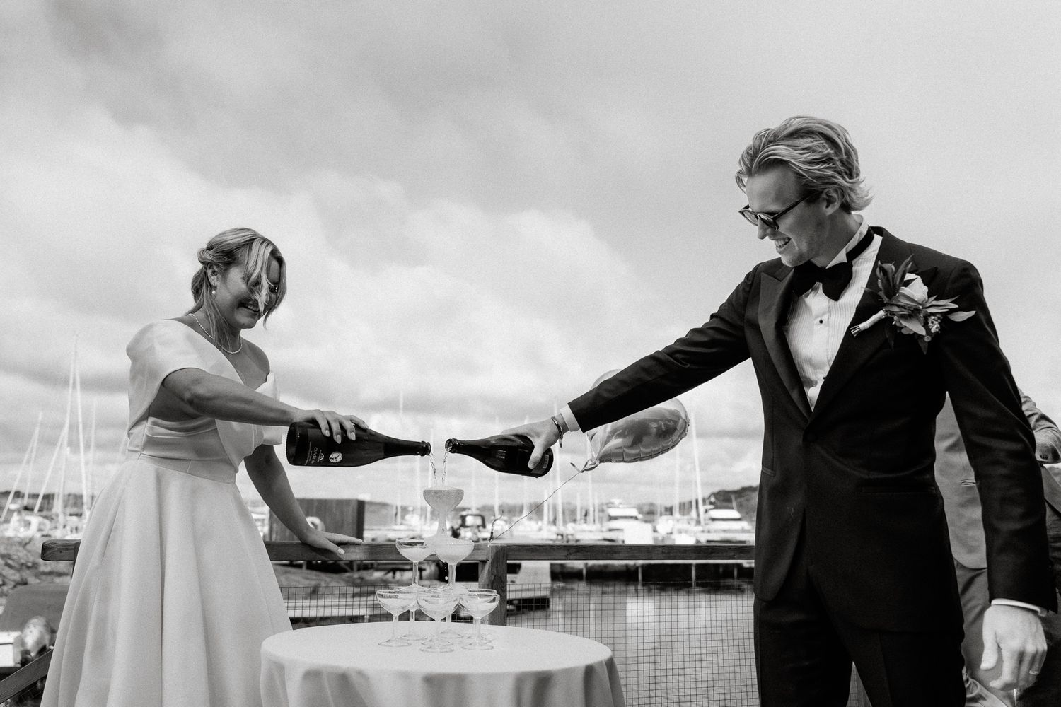 A couple dances together at an outdoor event, with the groom's jacket flowing in the breeze.