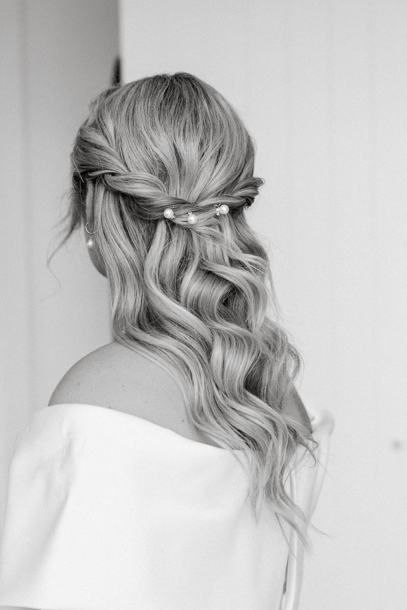 Four views of a romantic waterfall braided hairstyle with soft waves shown from different angles on blonde hair.