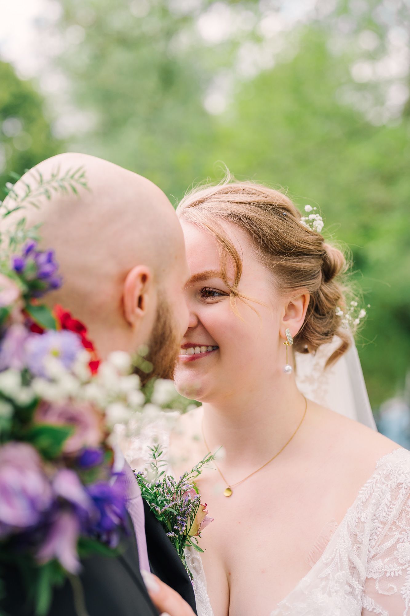 A romantic wedding photo series of tender moments and laughter between a couple in a garden setting.