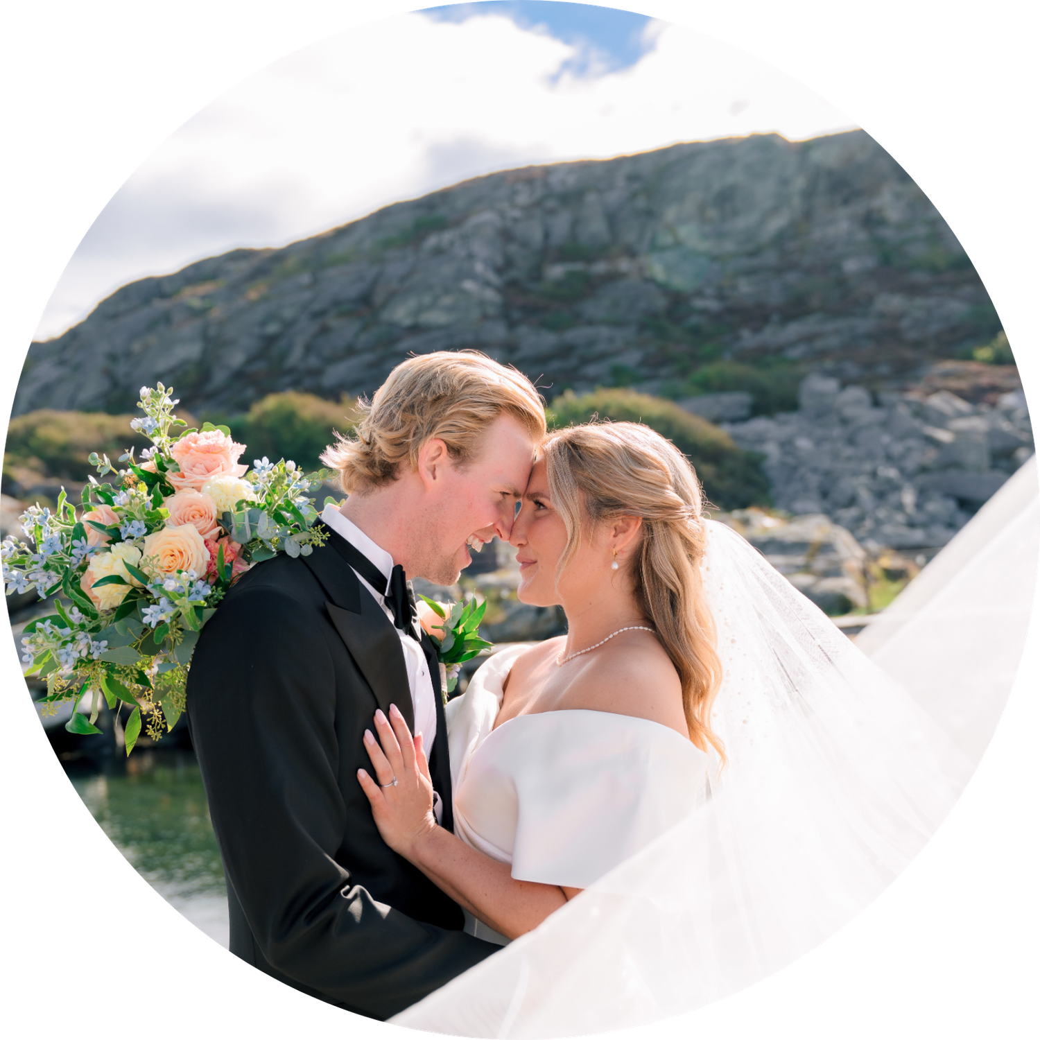 Romantic wedding couple sharing intimate moments against scenic coastal cliffs and mountains.