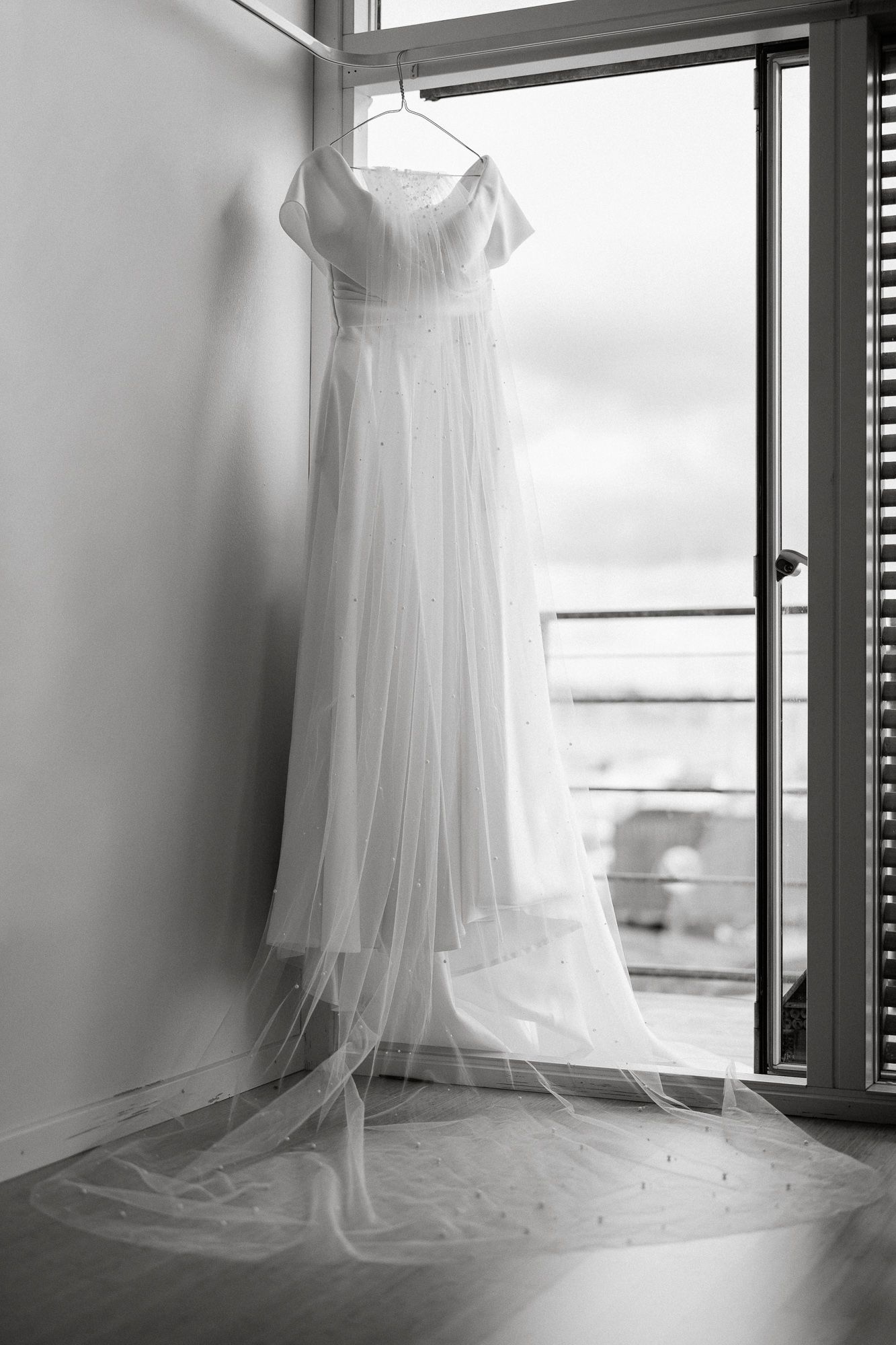 Multiple views of an elegant white wedding dress hanging in a bright window with soft natural light.