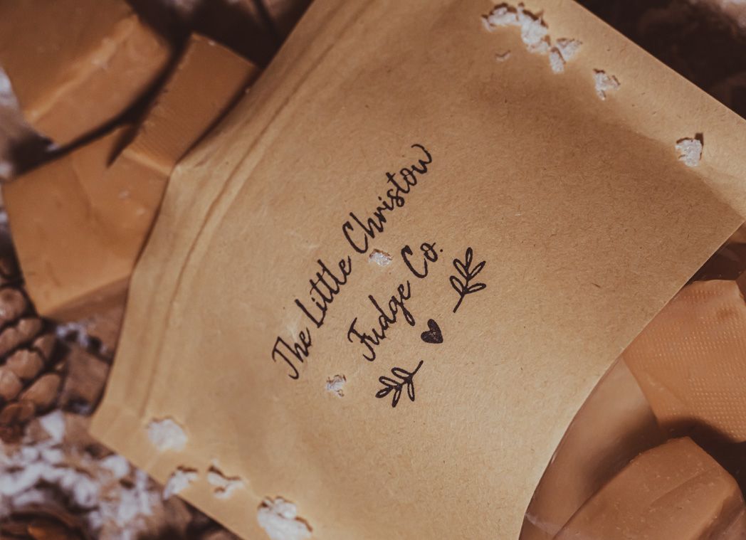 Brown kraft paper package with handwritten calligraphy text and botanical designs.