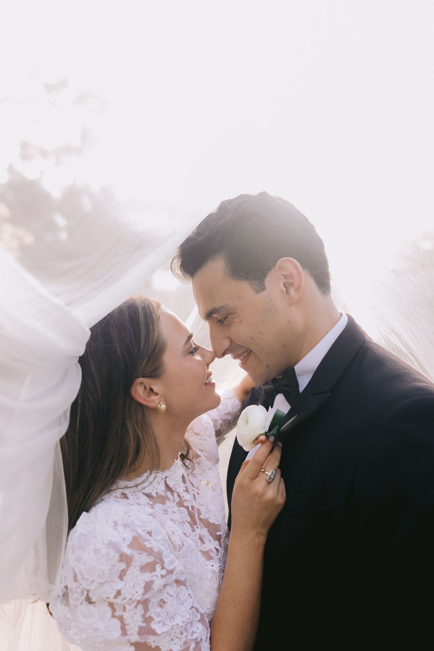 A romantic wedding photo collage showing three intimate moments between newlyweds against a soft white veil background.