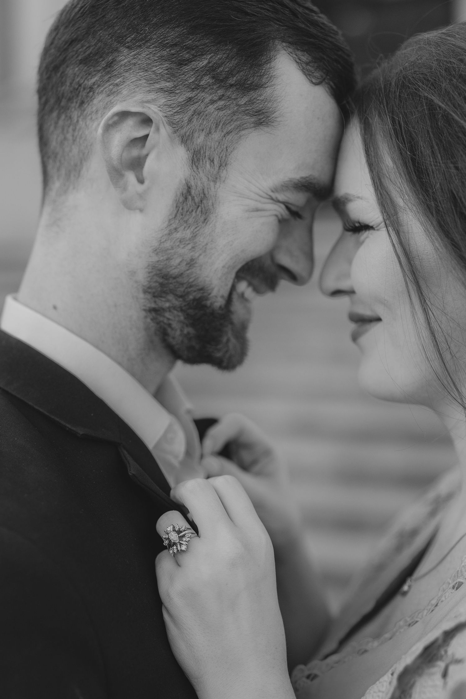 A romantic black and white close-up portrait of a couple in an intimate and tender moment.