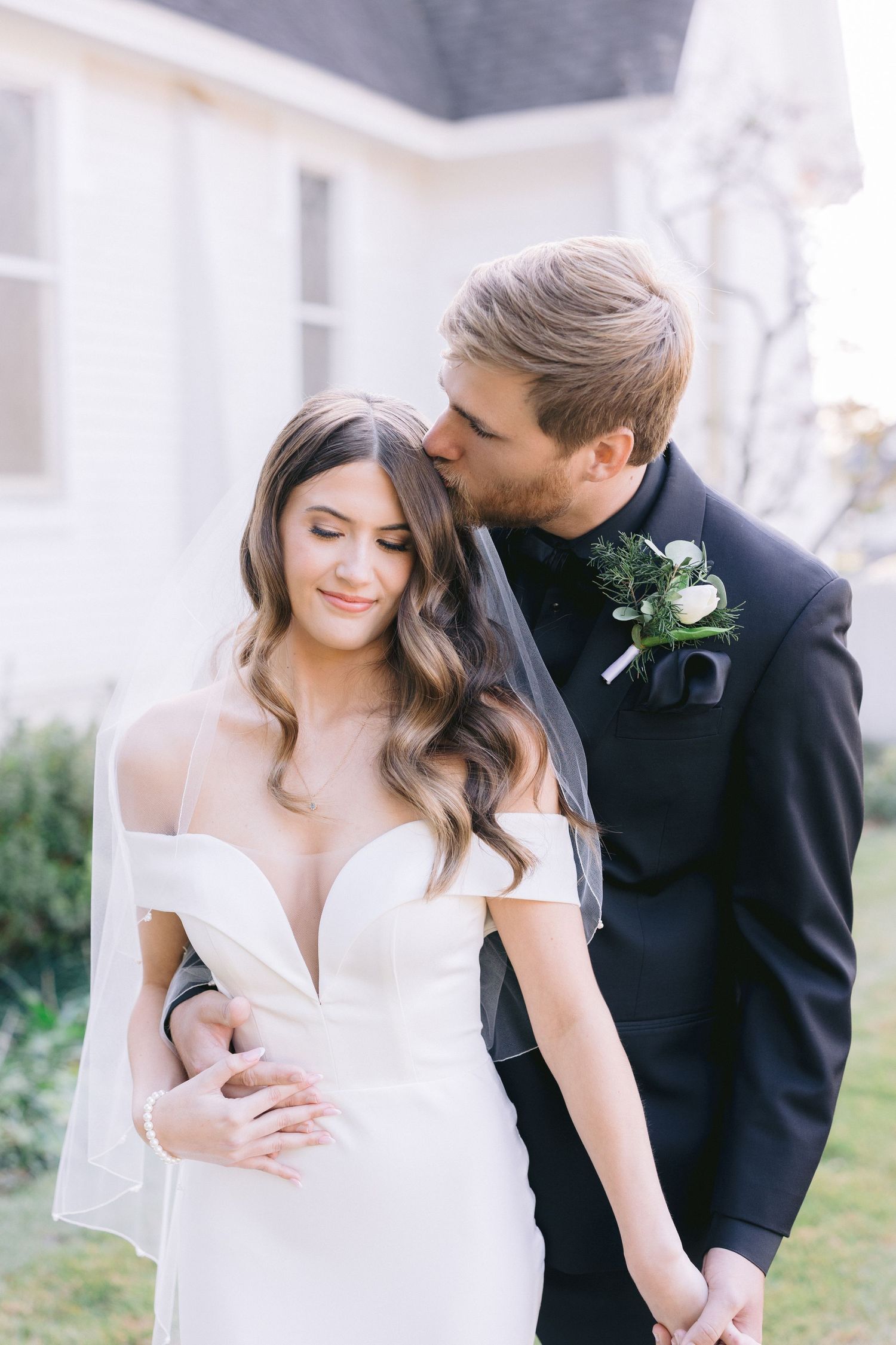 Romantic wedding couple shares intimate moments in soft natural lighting.