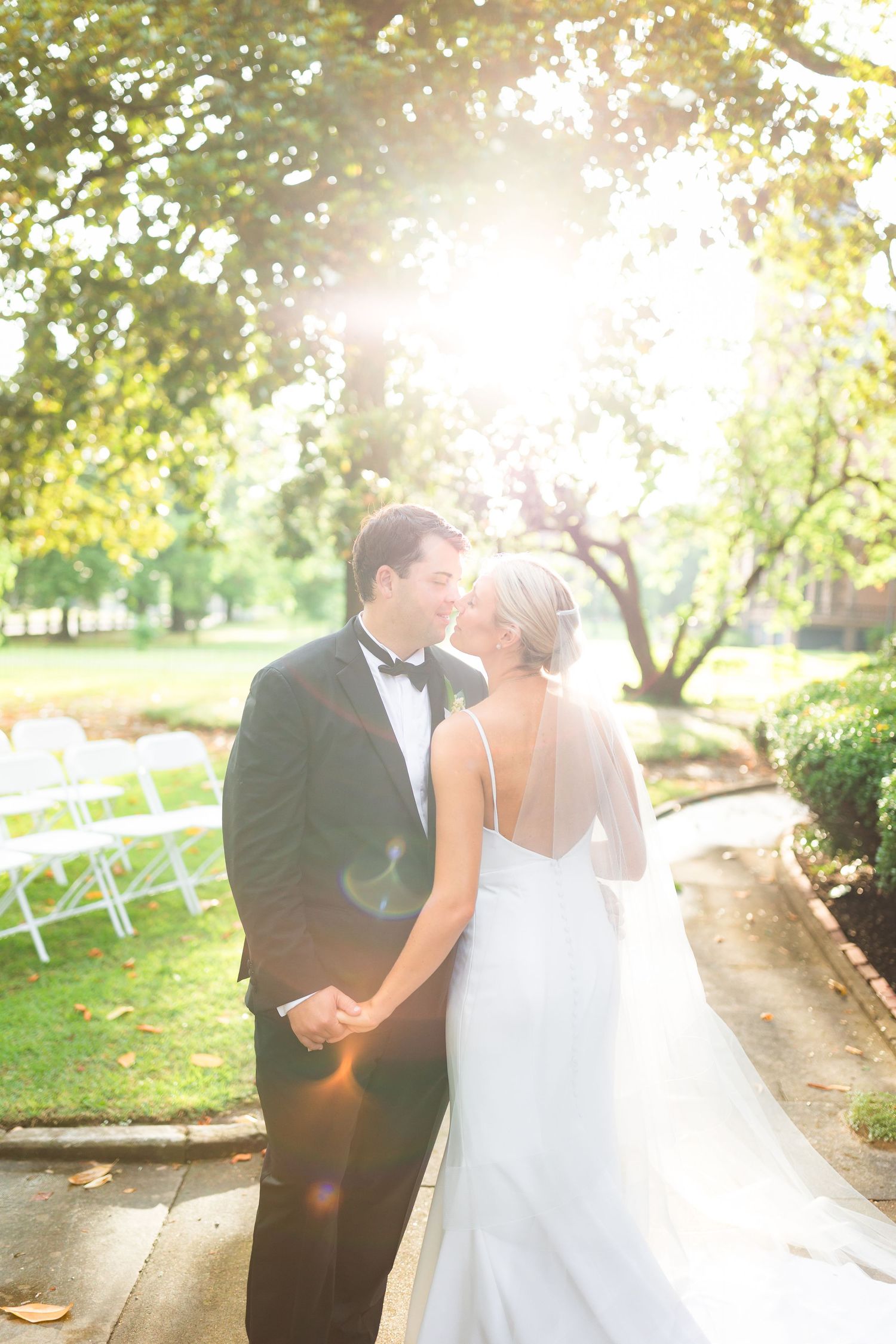 Golden sunlight illuminates romantic wedding portraits in a garden setting.