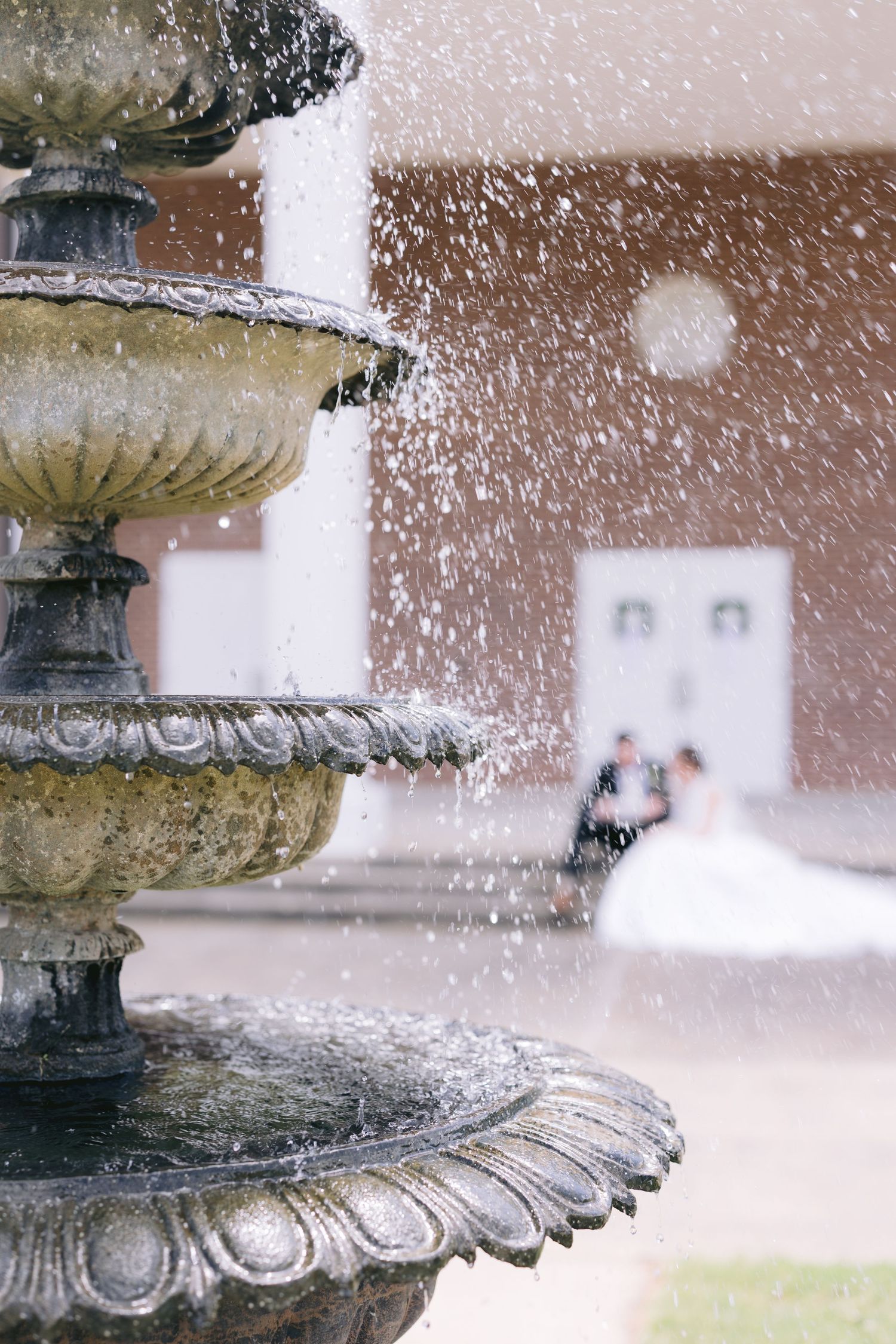 Close-up of water droplets splashing on ornate stone fountain edges in snowy conditions.