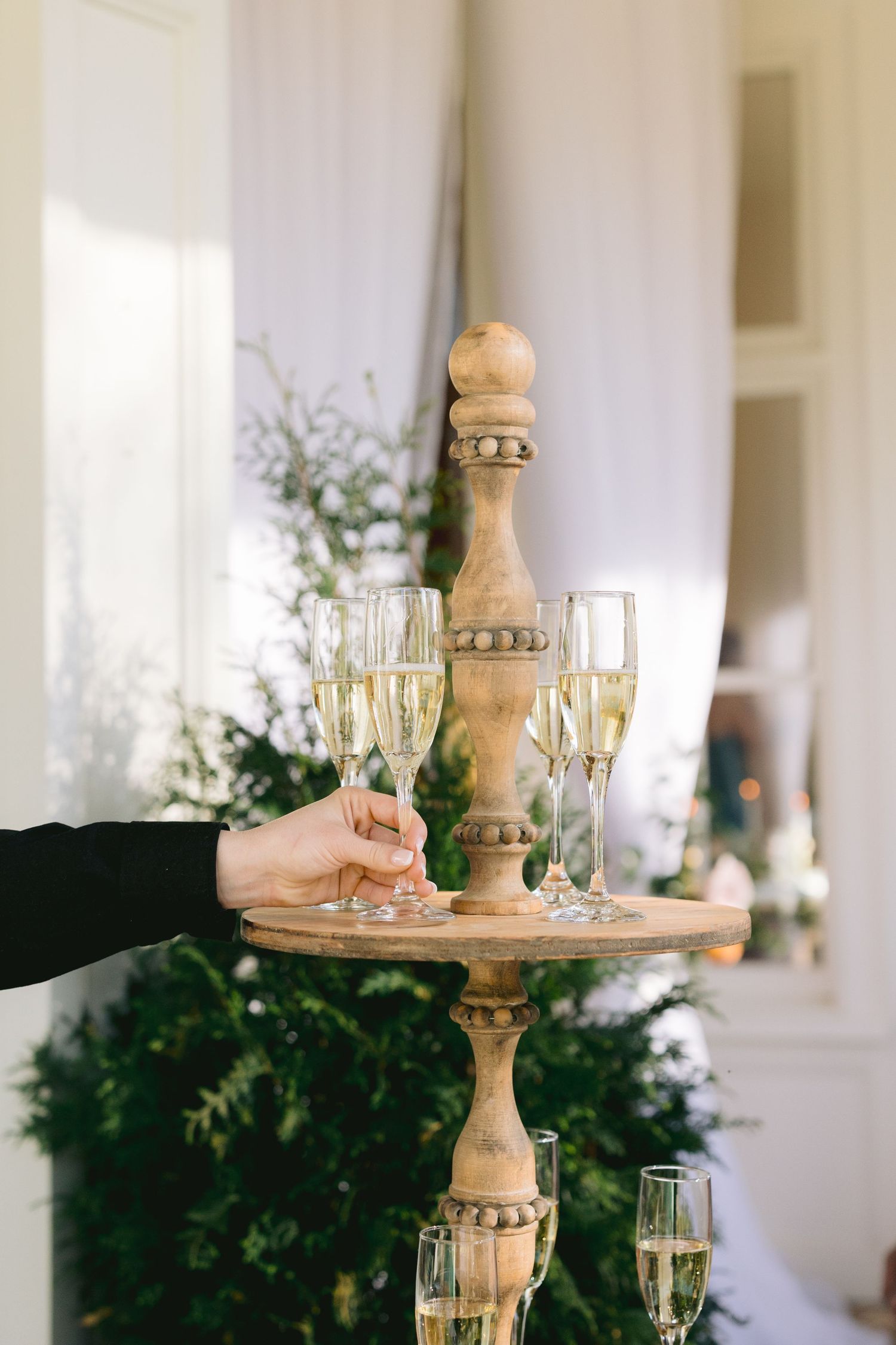 Elegant wedding reception table setting with wooden cake stands and champagne glasses.