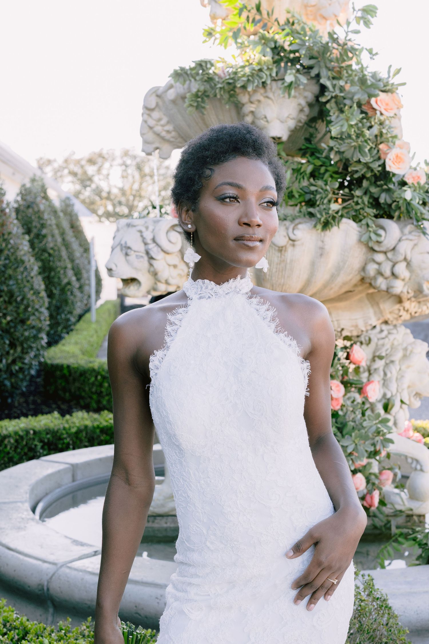 Beautiful white lace wedding dress detail against garden greenery at sunset.