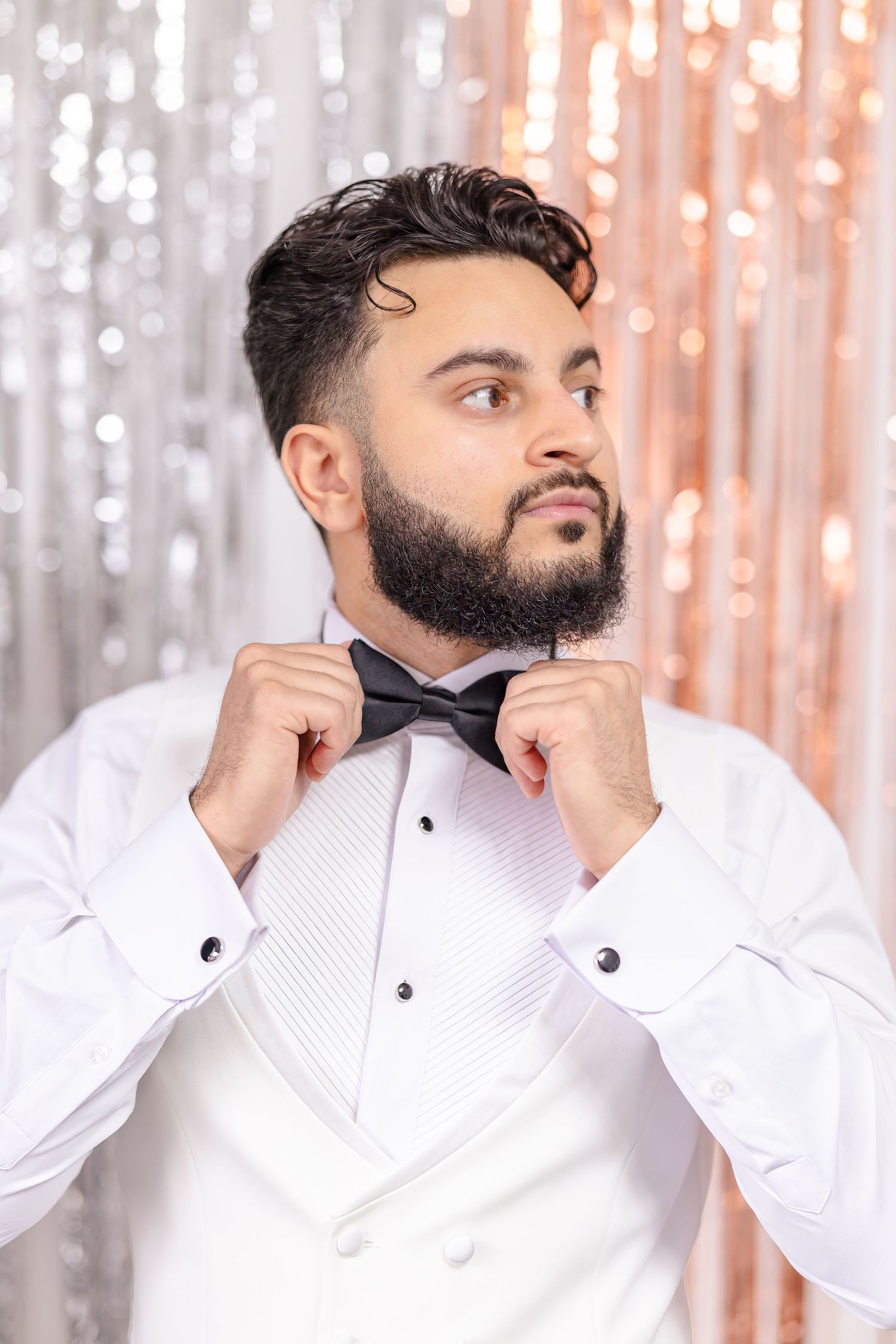 A four-panel sequence showing someone adjusting their bow tie while wearing a crisp white formal shirt.