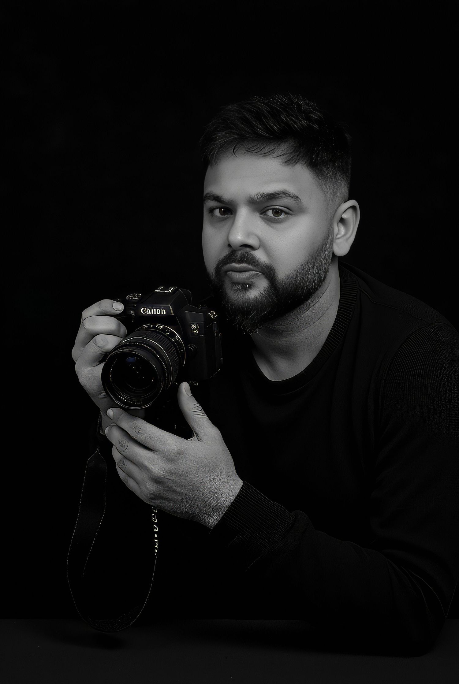Meet Irfan - A photographer in dark clothing holds a Canon camera against a black background in a series of artistic shots.