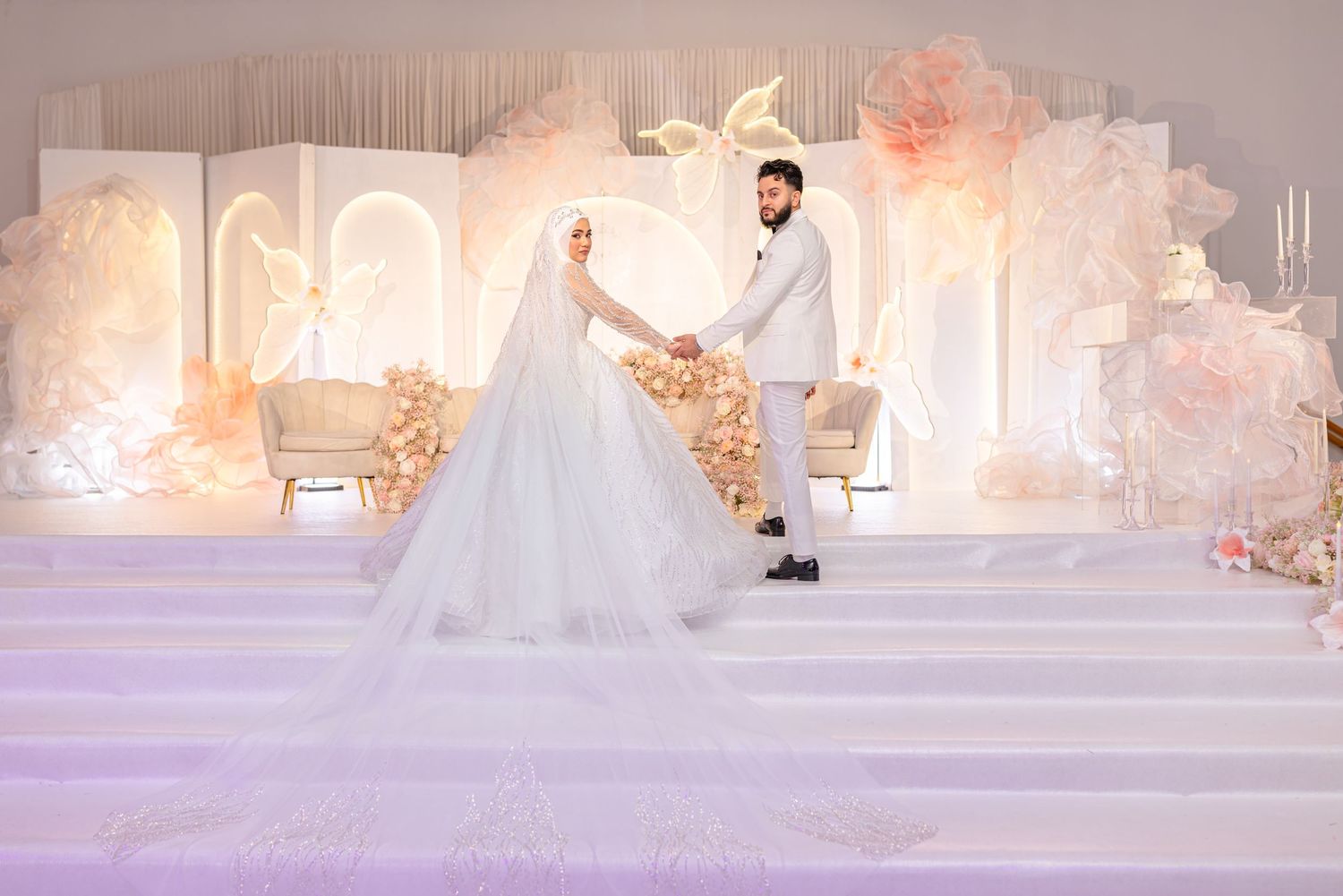 A romantic wedding scene with cascading floral arrangements and a bride in a flowing white gown.