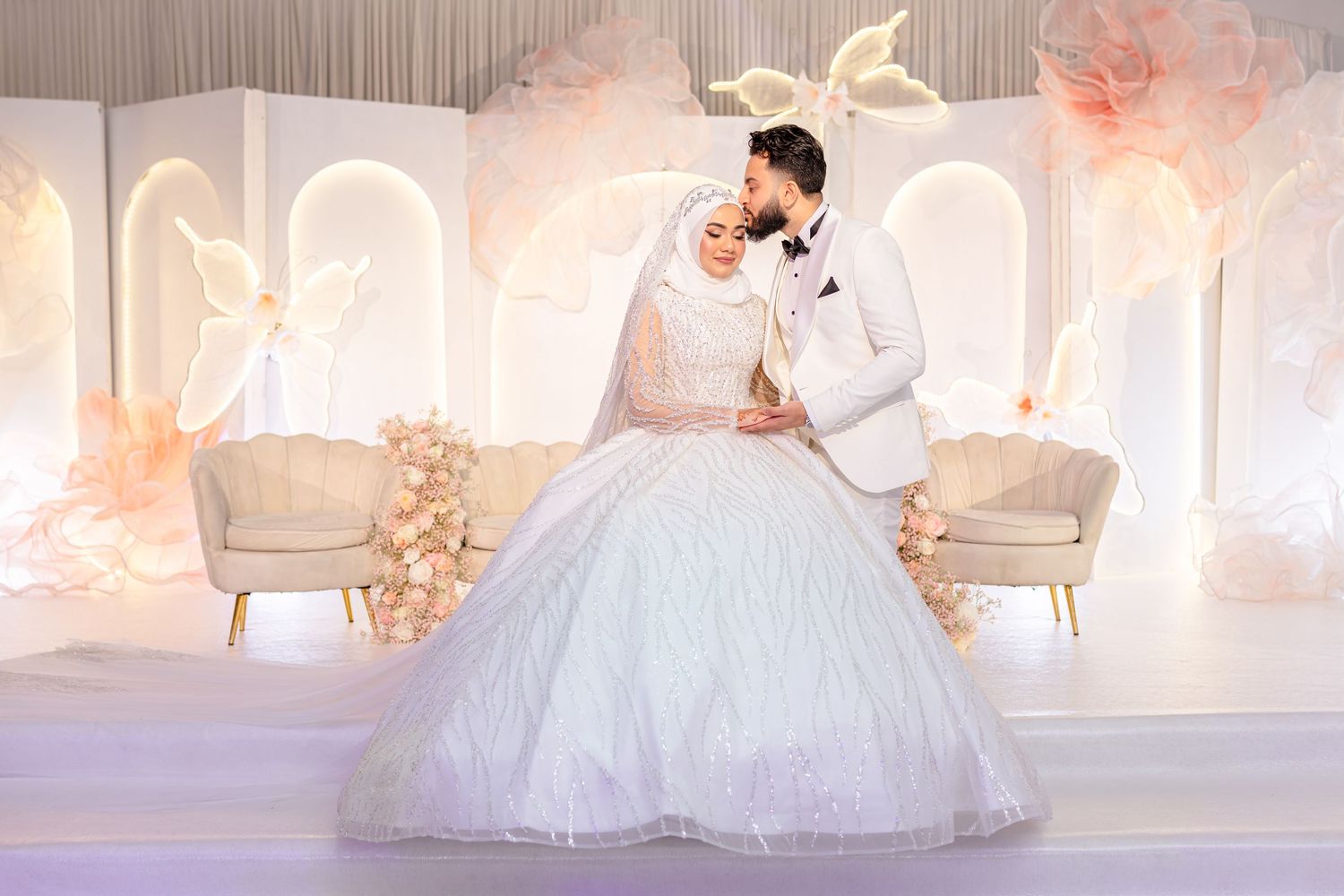 Dreamy wedding venue with white draping, soft lighting, and floral decor creating a romantic atmosphere.