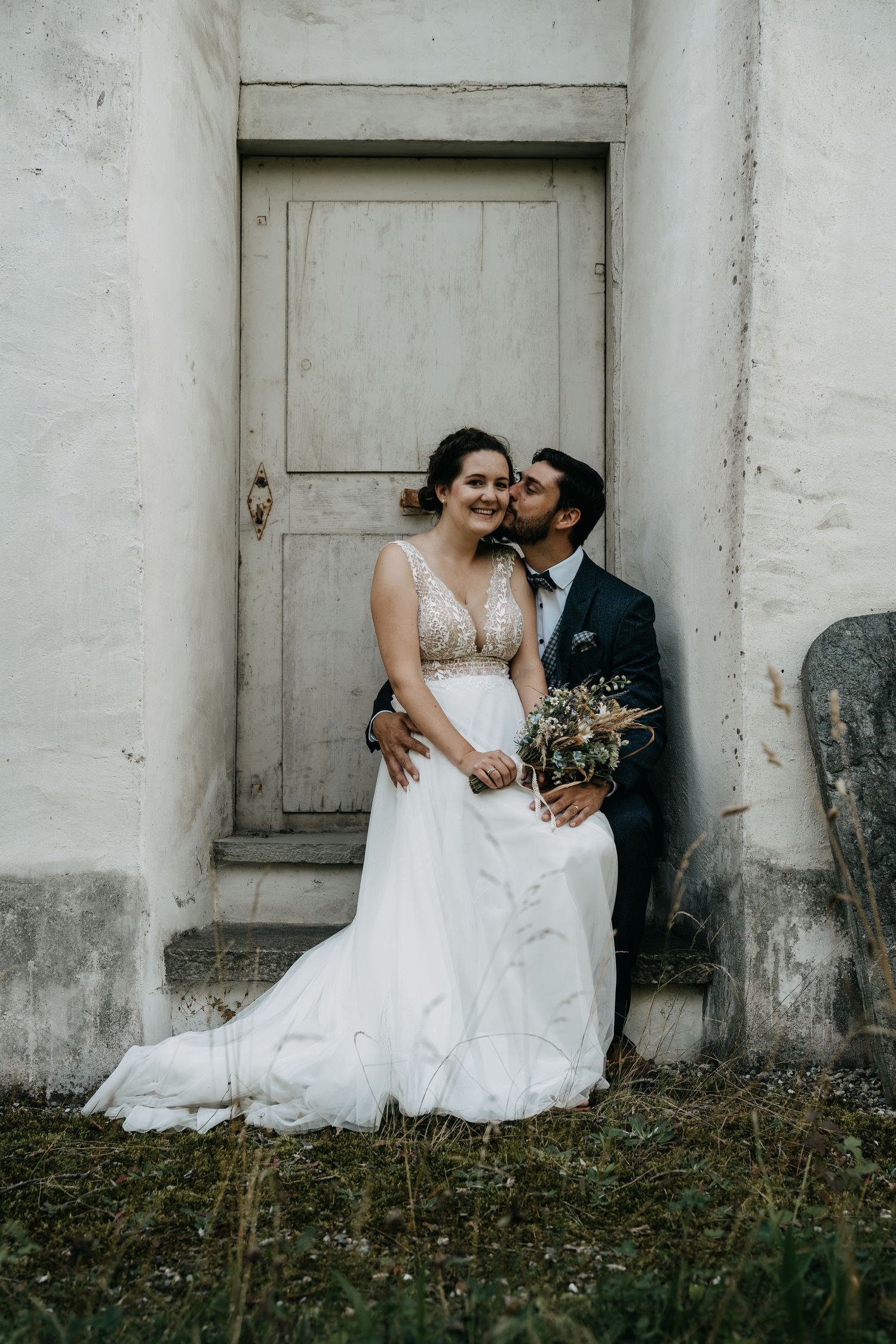 Romantisches Hochzeitspaar auf Treppe Schloss Reichenau Graubünden Schweiz – professionelle, authentische Hochzeitsfotos von Mediasquad Swit