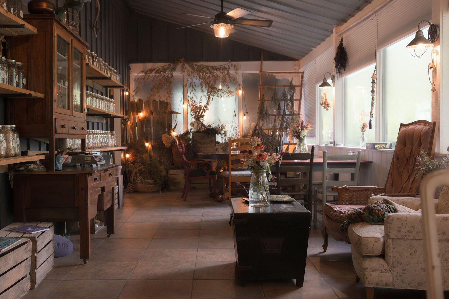 Rustic vintage shop interior with wooden shelves, antique furniture, cozy armchairs, and warm lighting creating a charming atmosphere.
