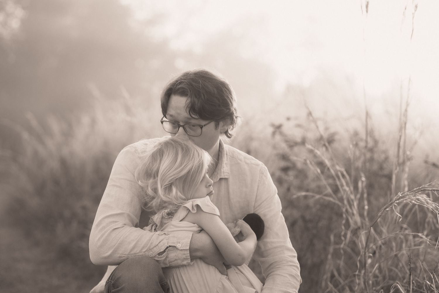 A series of black and white romantic photos showing intimate moments between a couple in an outdoor setting.