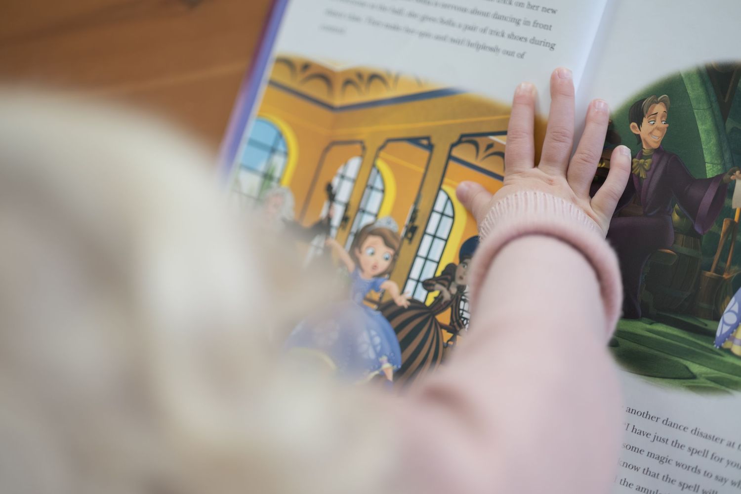 A person's hand flips through pages of a children's picture book showing colorful illustrations and text.