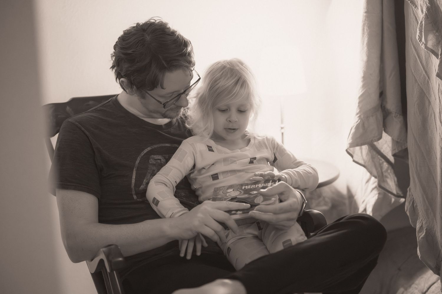 A series of black and white photos showing tender parent-child moments on a couch.