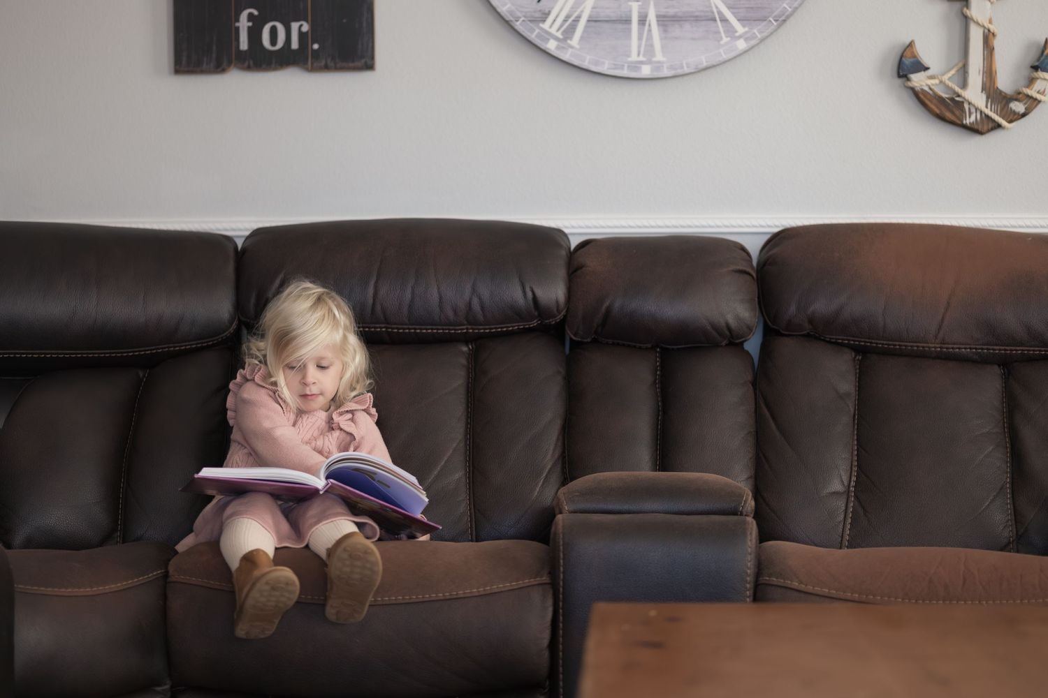 A sequence of photos shows a person lying down and gradually disappearing behind a brown leather couch.