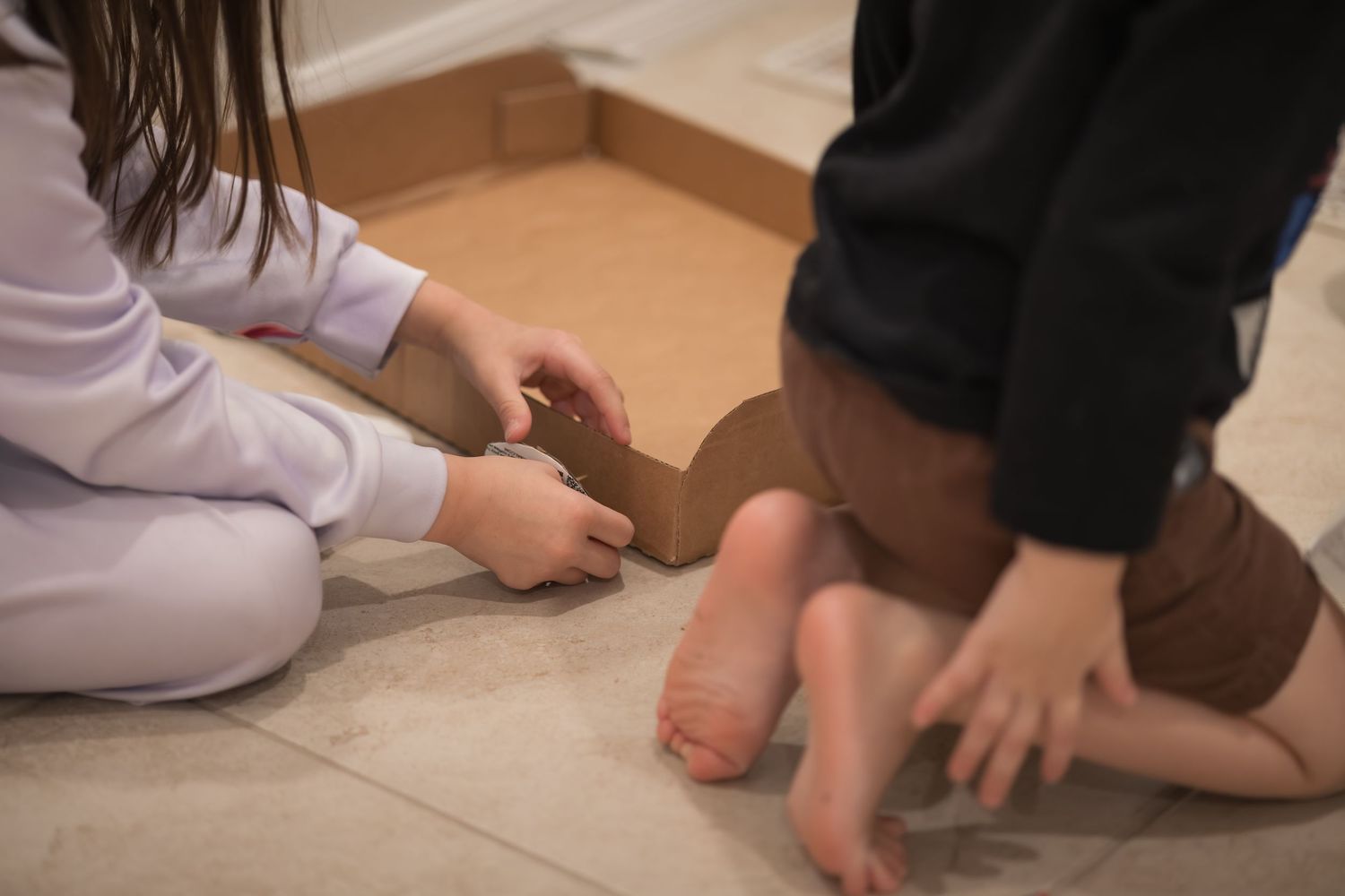 Hands building on a tiled floor during playtime.