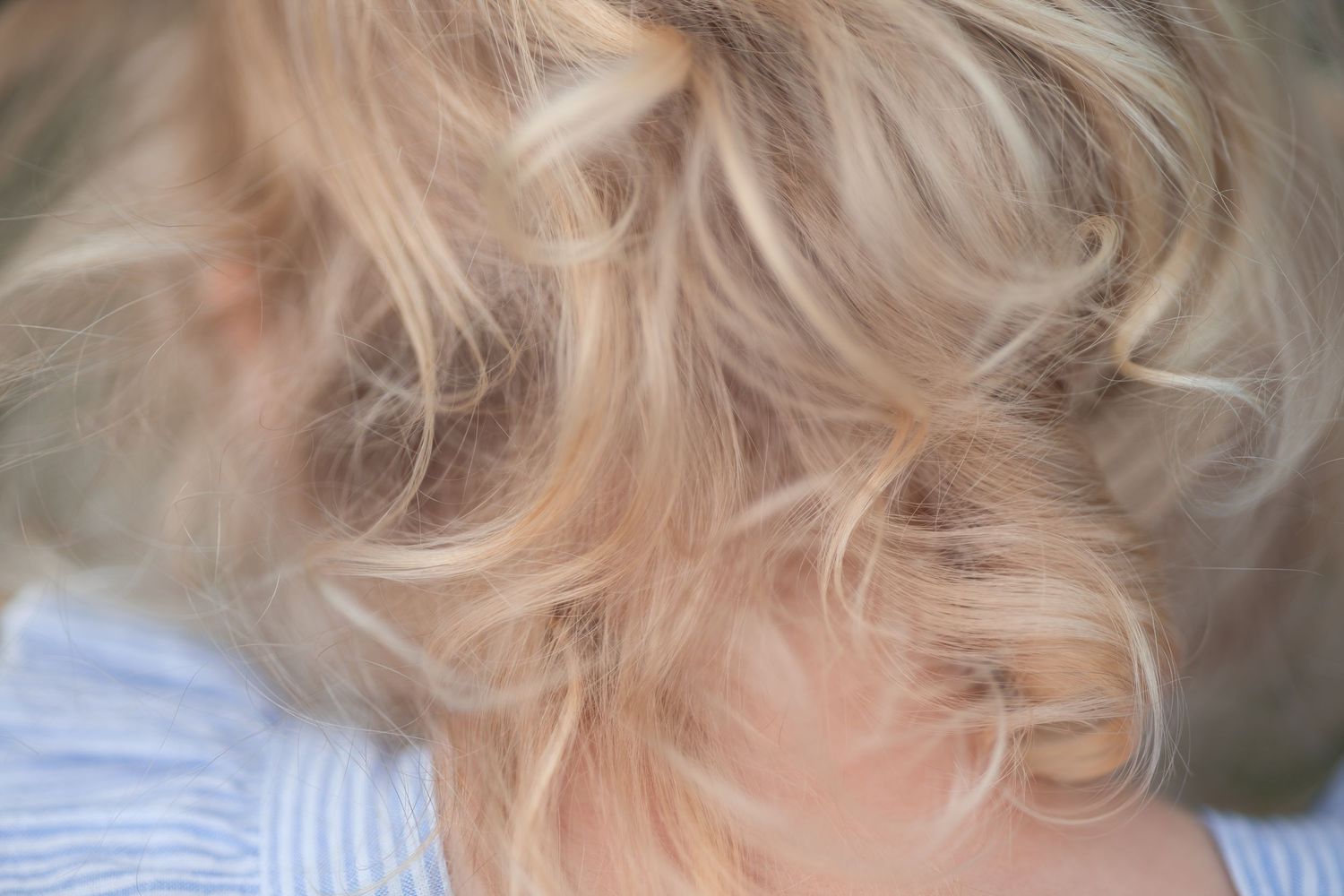 Close-up of soft blonde curls with natural lighting.