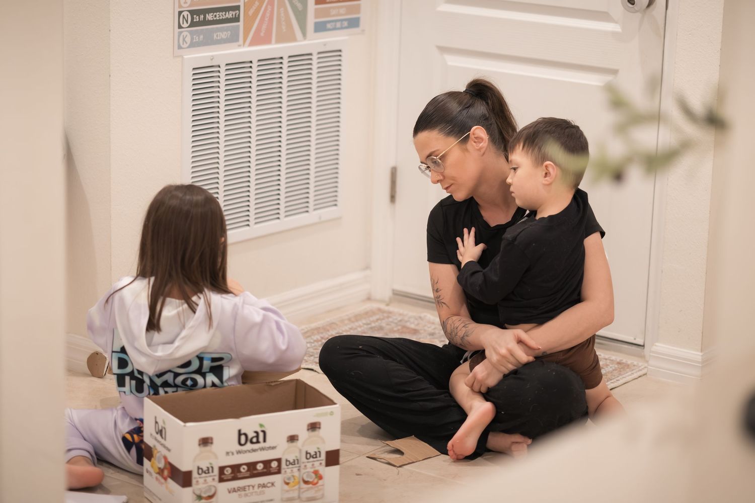 Family gathered around a table doing arts and crafts together in a cozy home setting.