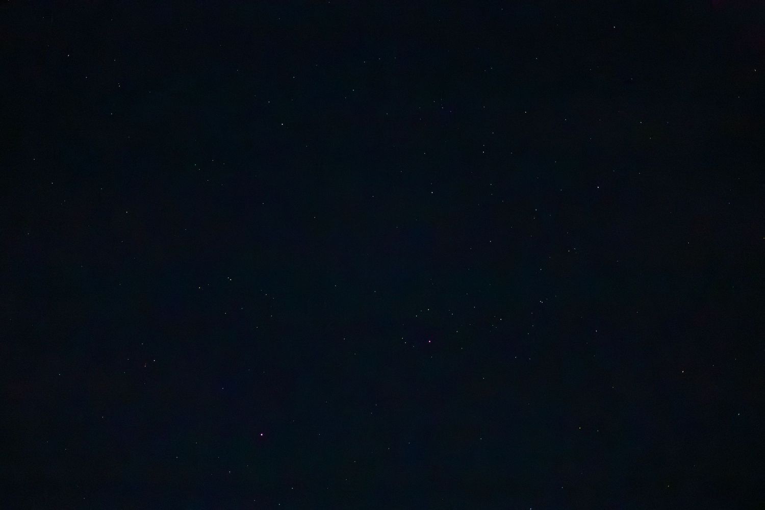 Dark night sky filled with faint stars and a deep teal hue, perfect for astronomy and stargazing backgrounds.