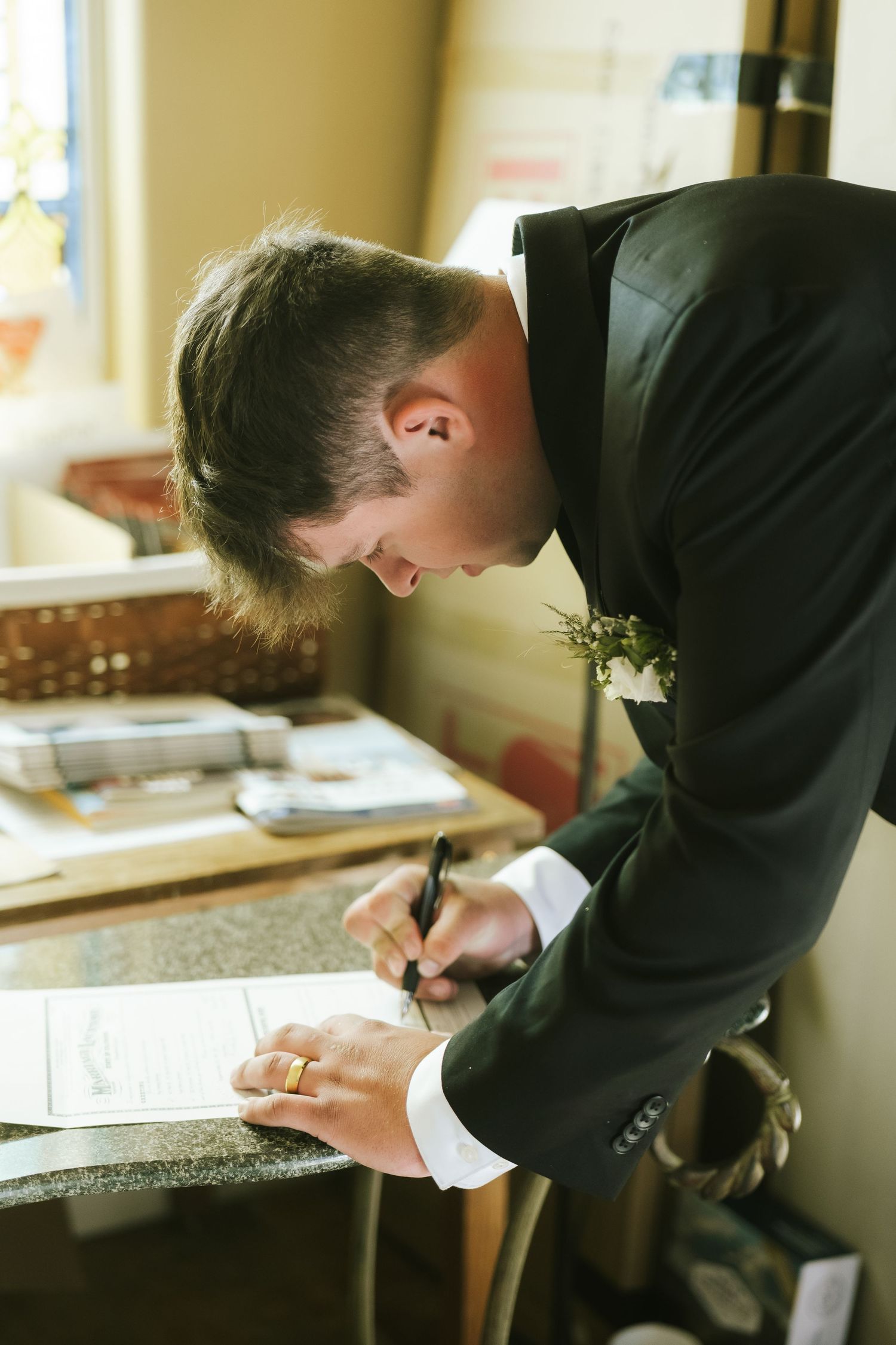 groom signing marriage certificate