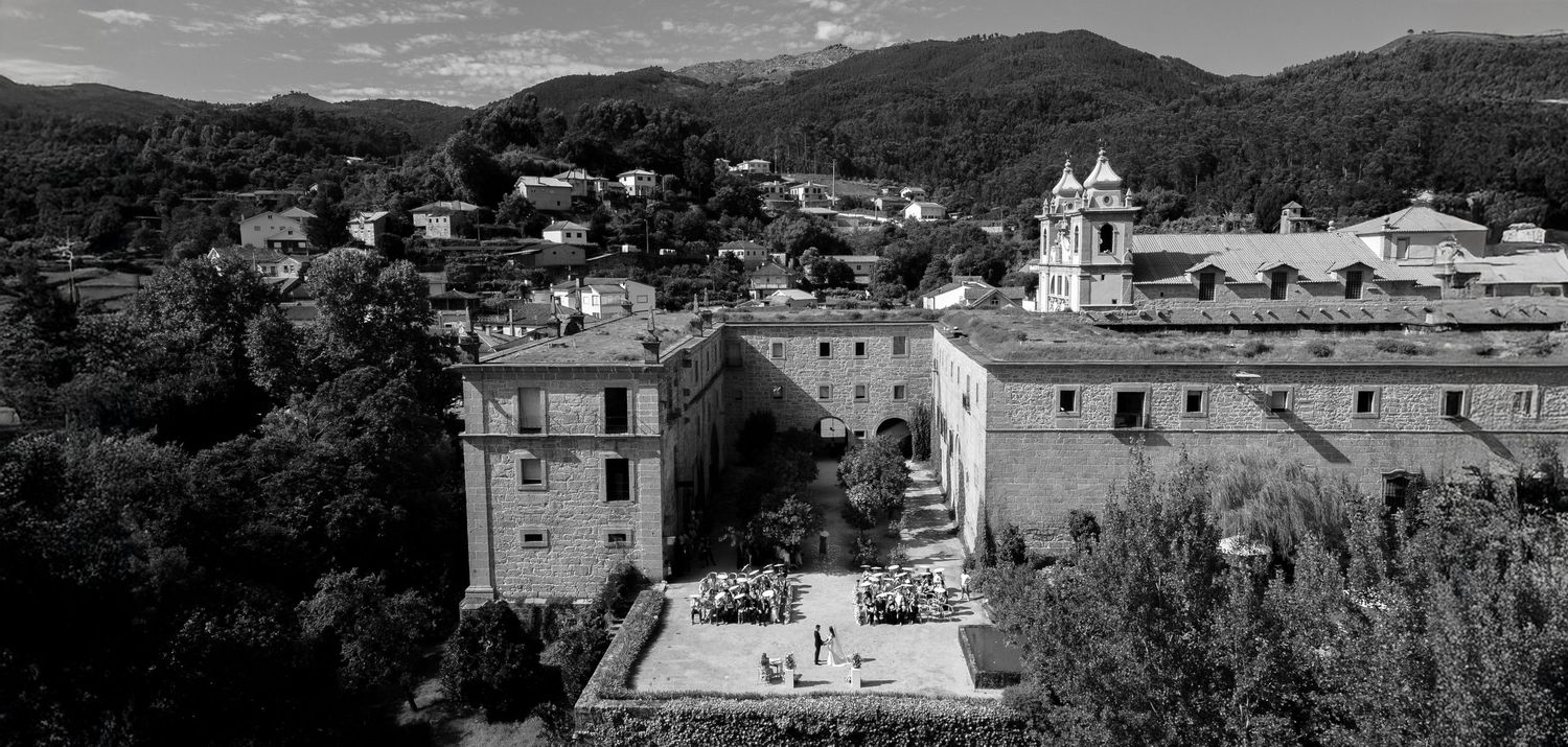Black and white panoramic cityscape view of a historic mountain town with traditional architecture and surrounding hills.
