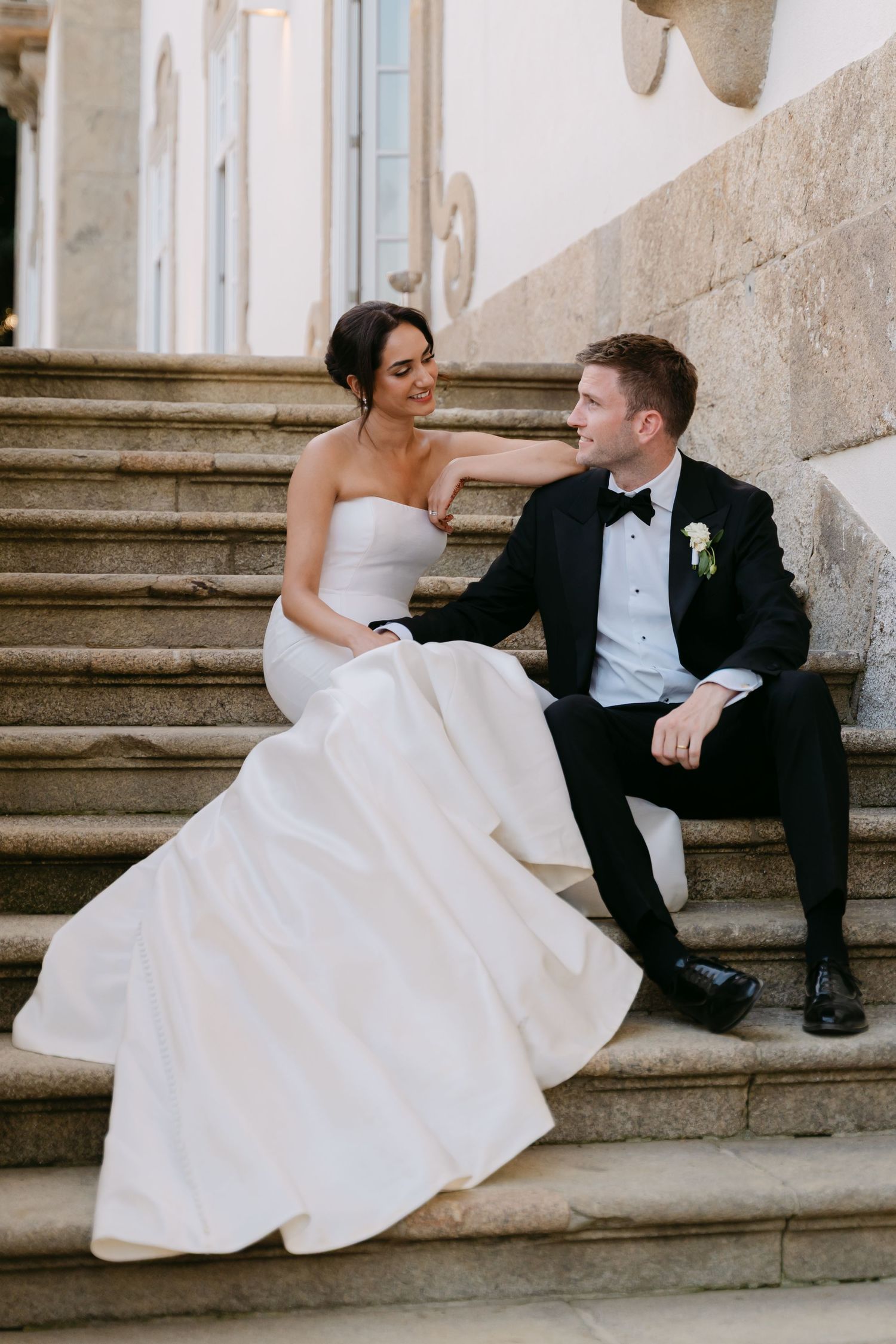 A series of romantic wedding photos showing a couple sitting on stone steps in formal attire.