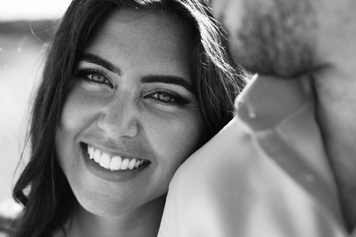 Close-up black and white portrait showing joyful expressions and natural smiles.