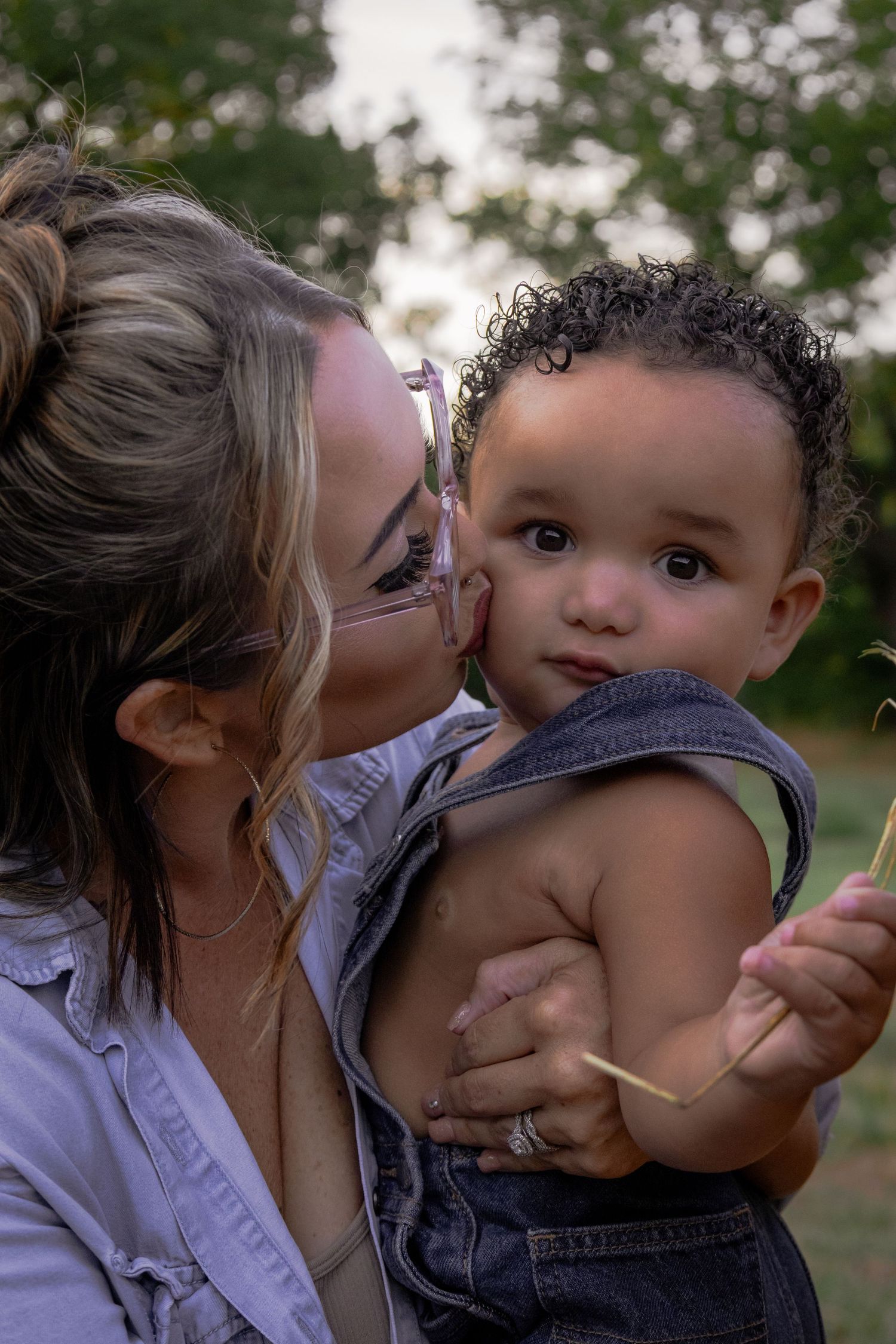 A tender moment captured in a series of candid outdoor photos showing affectionate interaction between parent and child.