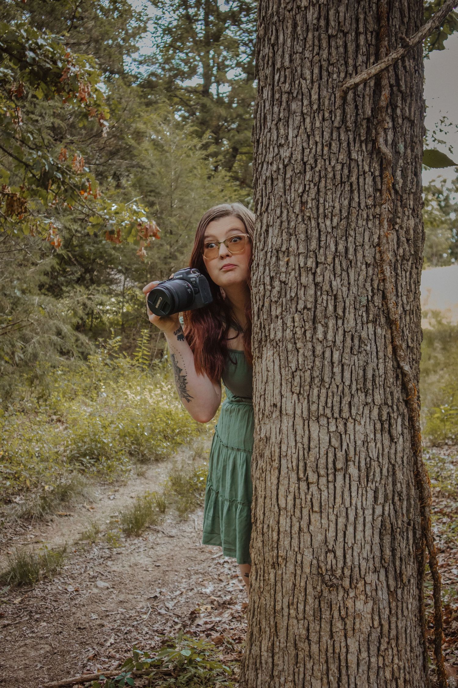 A playful sequence shows someone peeking out from behind a large tree trunk in a wooded outdoor setting.
