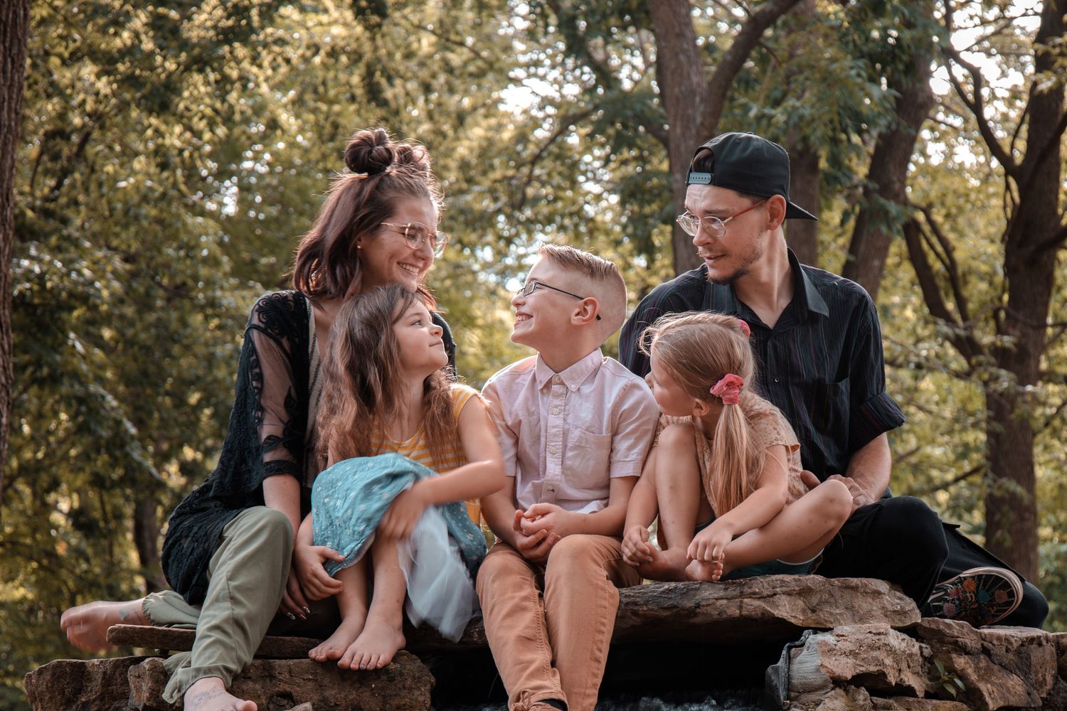 A collection of candid moments showing couples embracing and laughing together in an outdoor wooded setting.