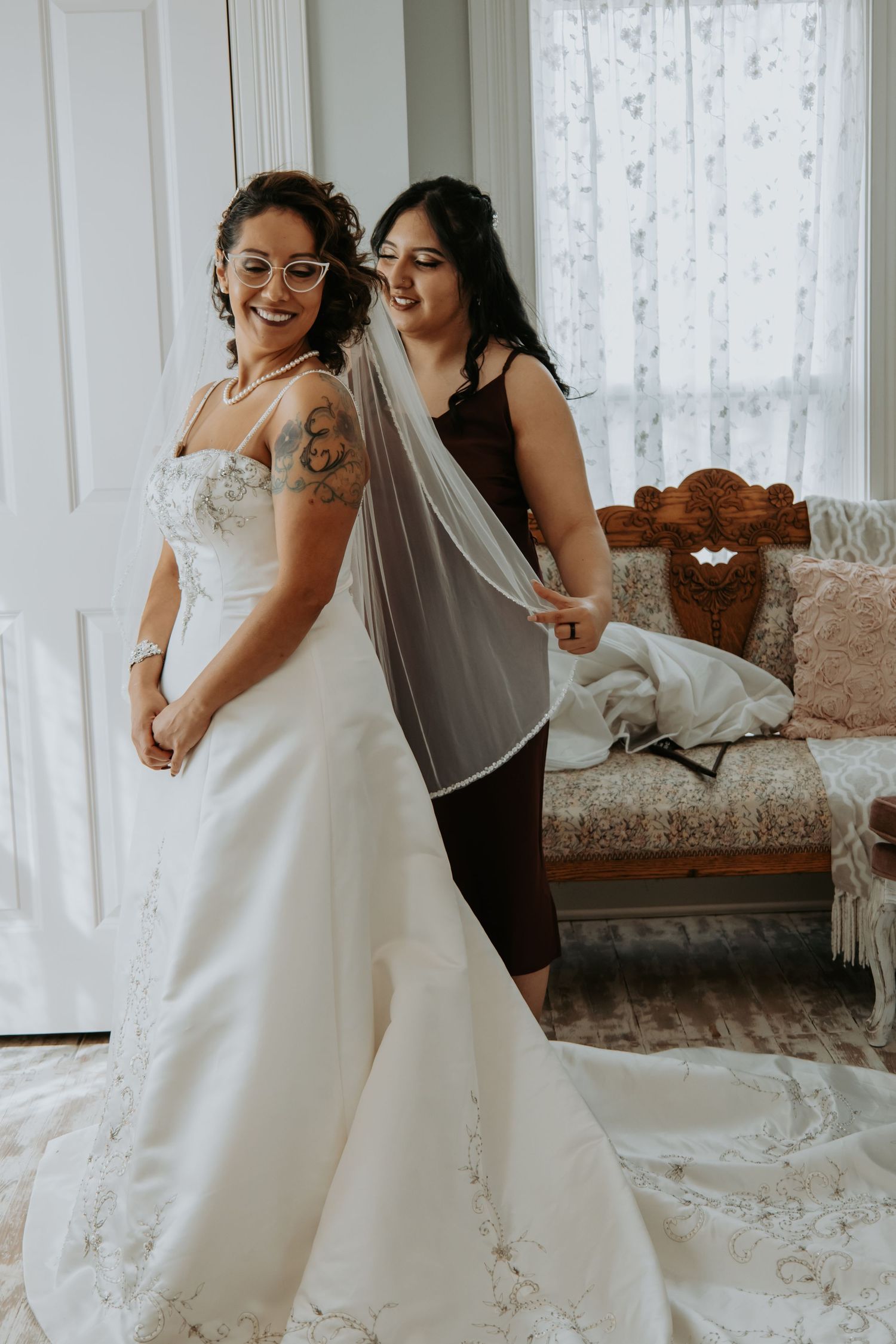 Beautiful wedding dress fitting moment showing the intricate details of a white gown with delicate lace and flowing train.