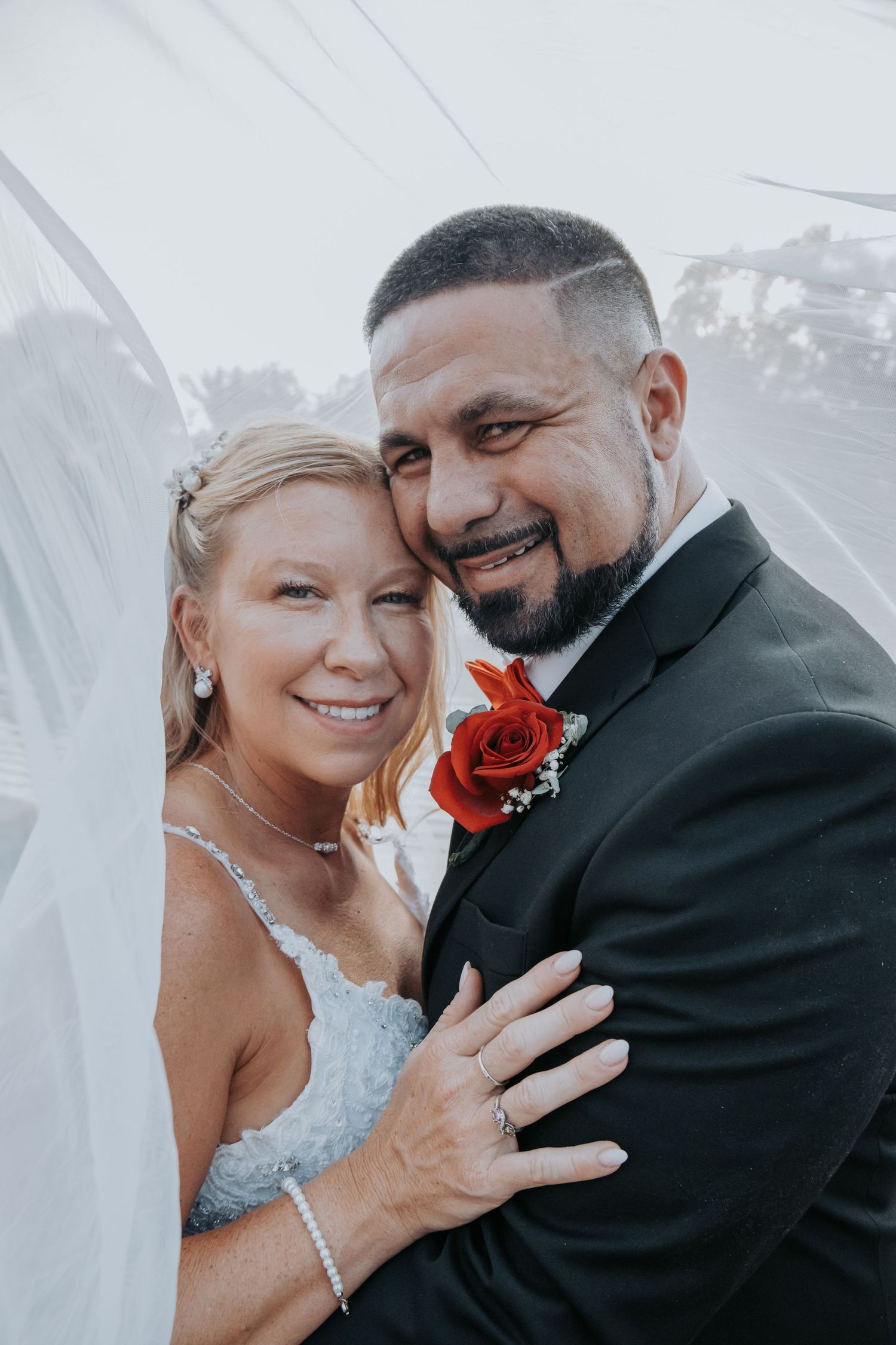 A romantic wedding couple shares intimate moments under a veil in a series of black and white photographs.