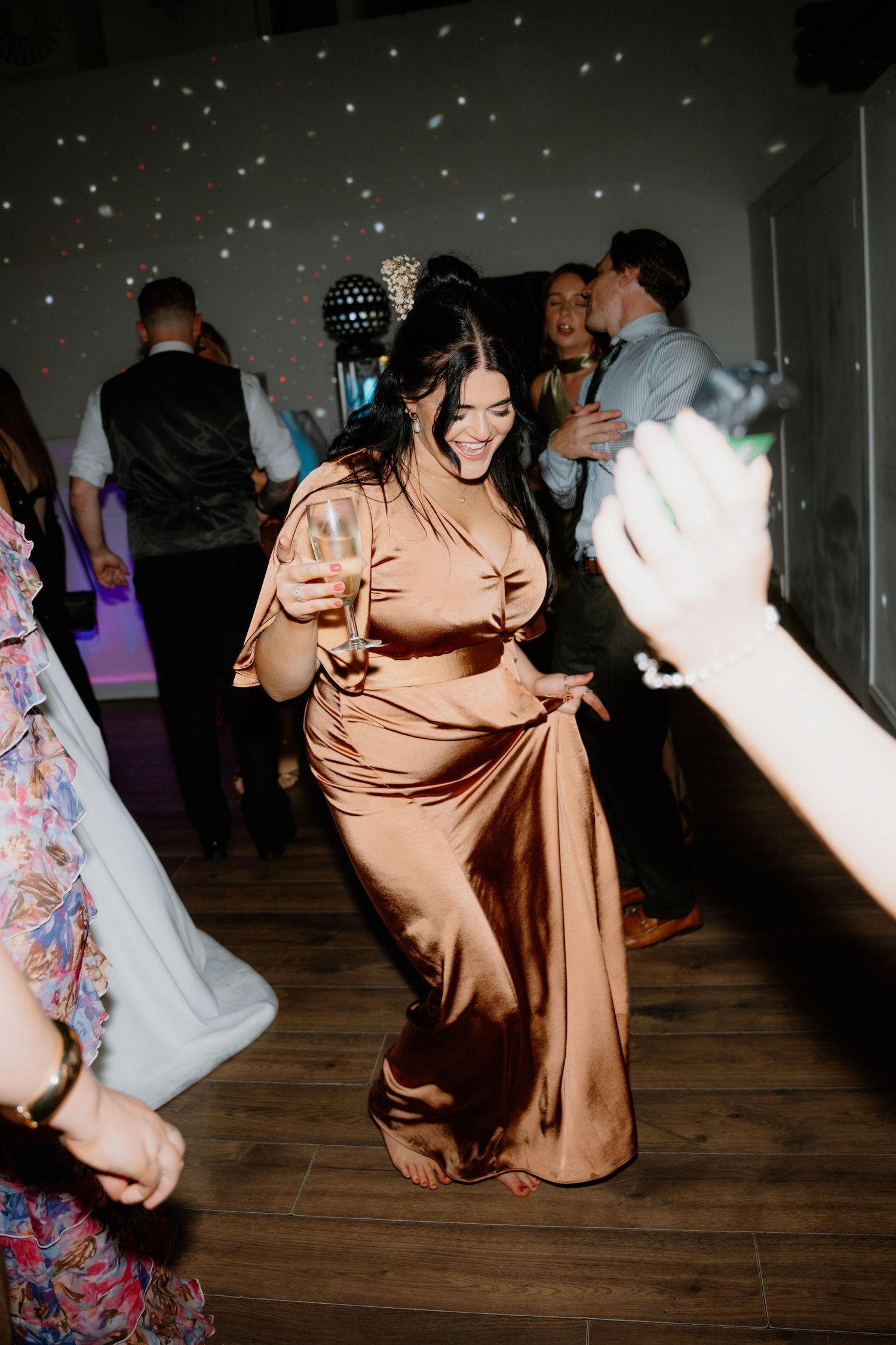 Wedding guests dance and celebrate on a wooden floor at a dimly lit reception venue. Glasgow Engine Works
