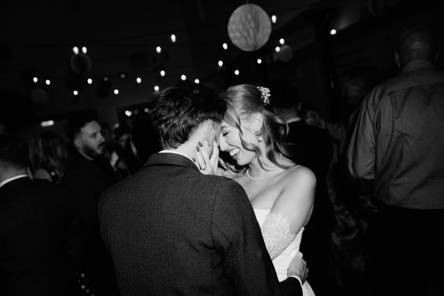 Black and white photographs of people dancing and socializing at a dimly lit nightclub or party.