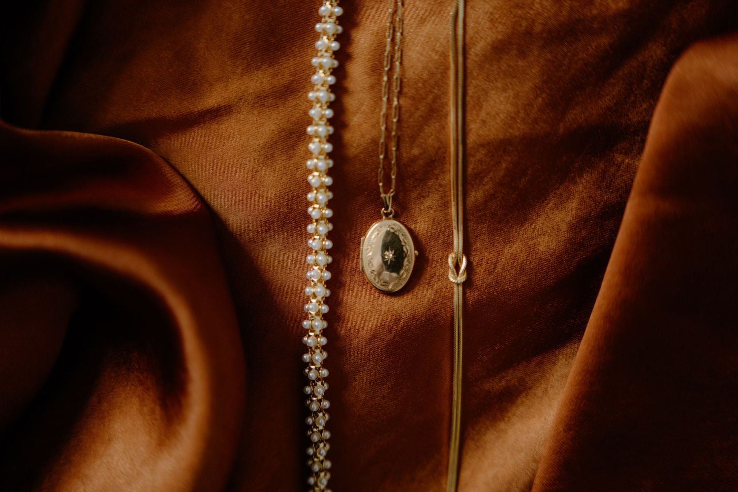 Macro shot of vintage leather bag with brass hardware and pearl beaded strap details in warm brown tones. Glasgow Engine Works