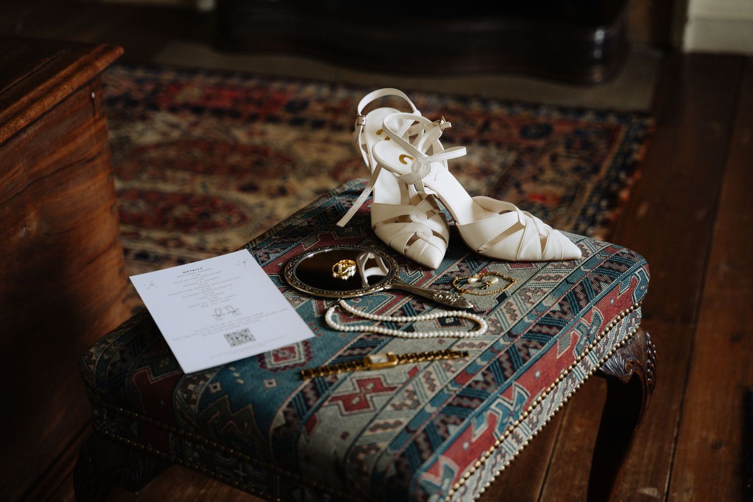 White baby shoes placed on vintage books with red decorative binding create a nostalgic nursery vignette.