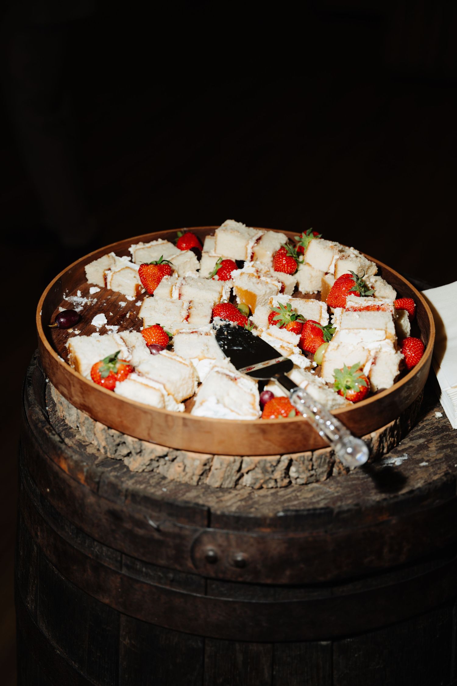 Sequence of clay pots filled with white desserts topped with fresh strawberries and chocolate shavings on a dark surface.